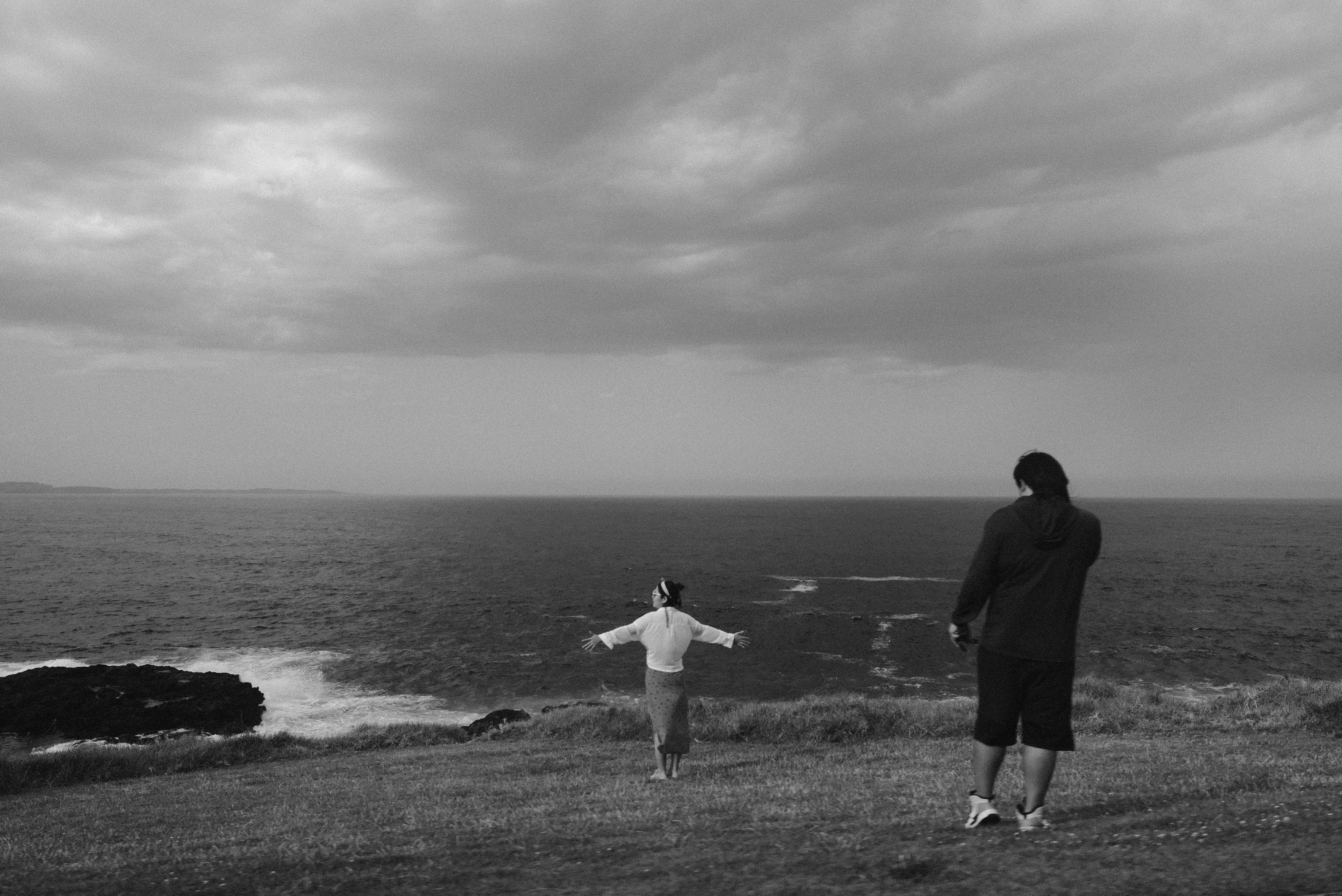 A couple of people standing on top of a grass covered field