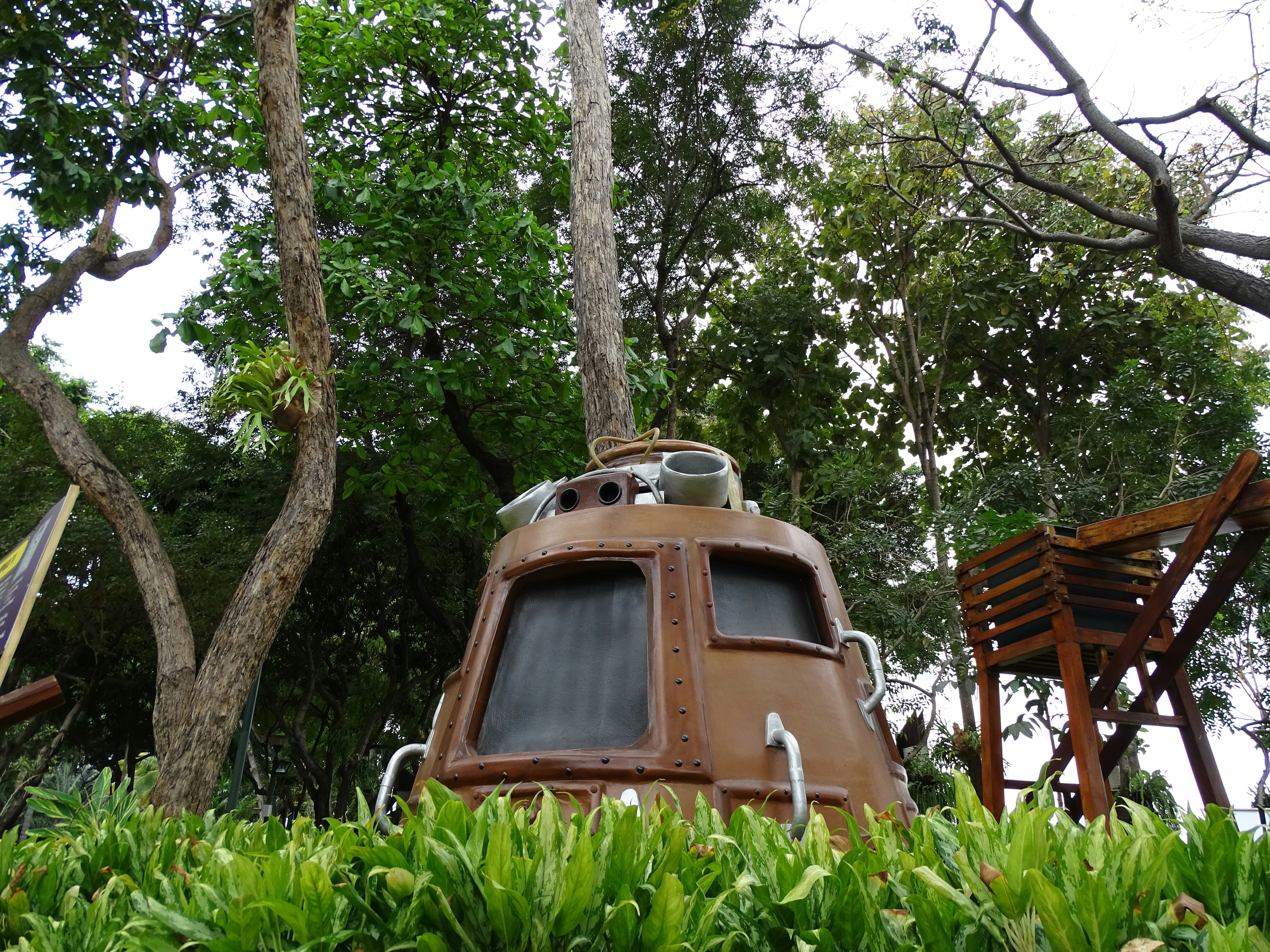 A house boat sitting in the middle of a lush green forest