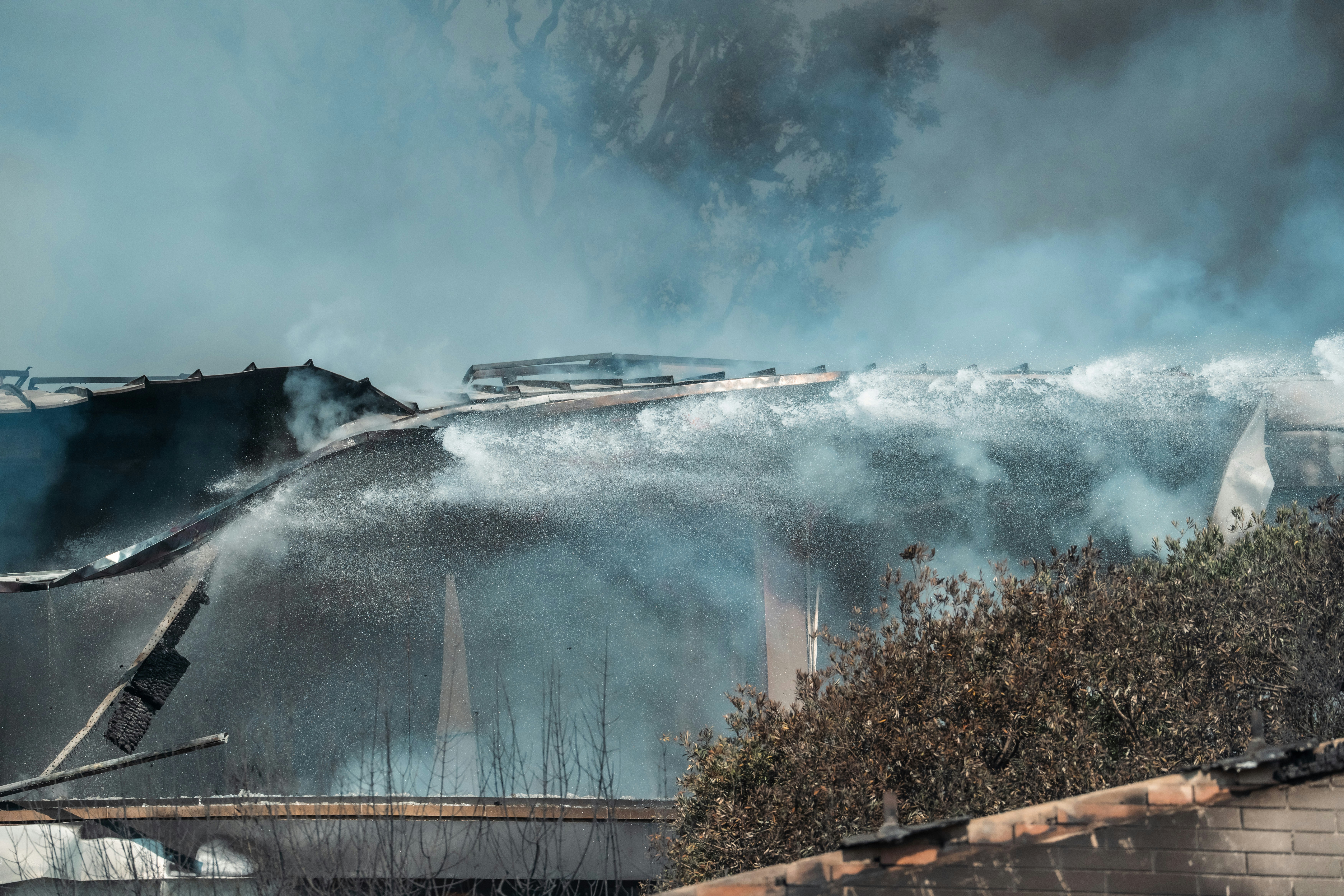A fire is raging out of the roof of a building photo – Free Current ...