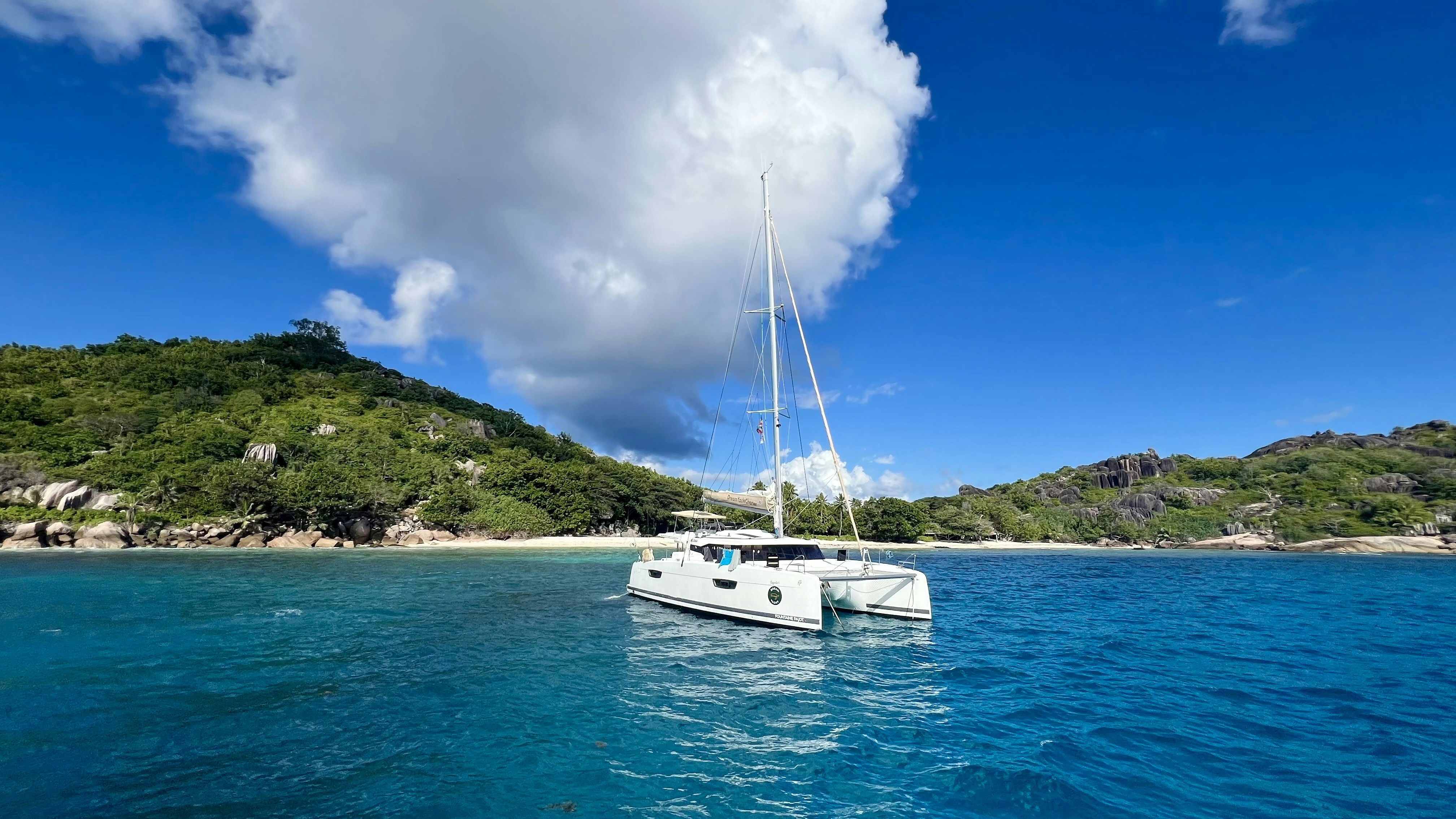 A white boat floating on top of a body of water in seychelles