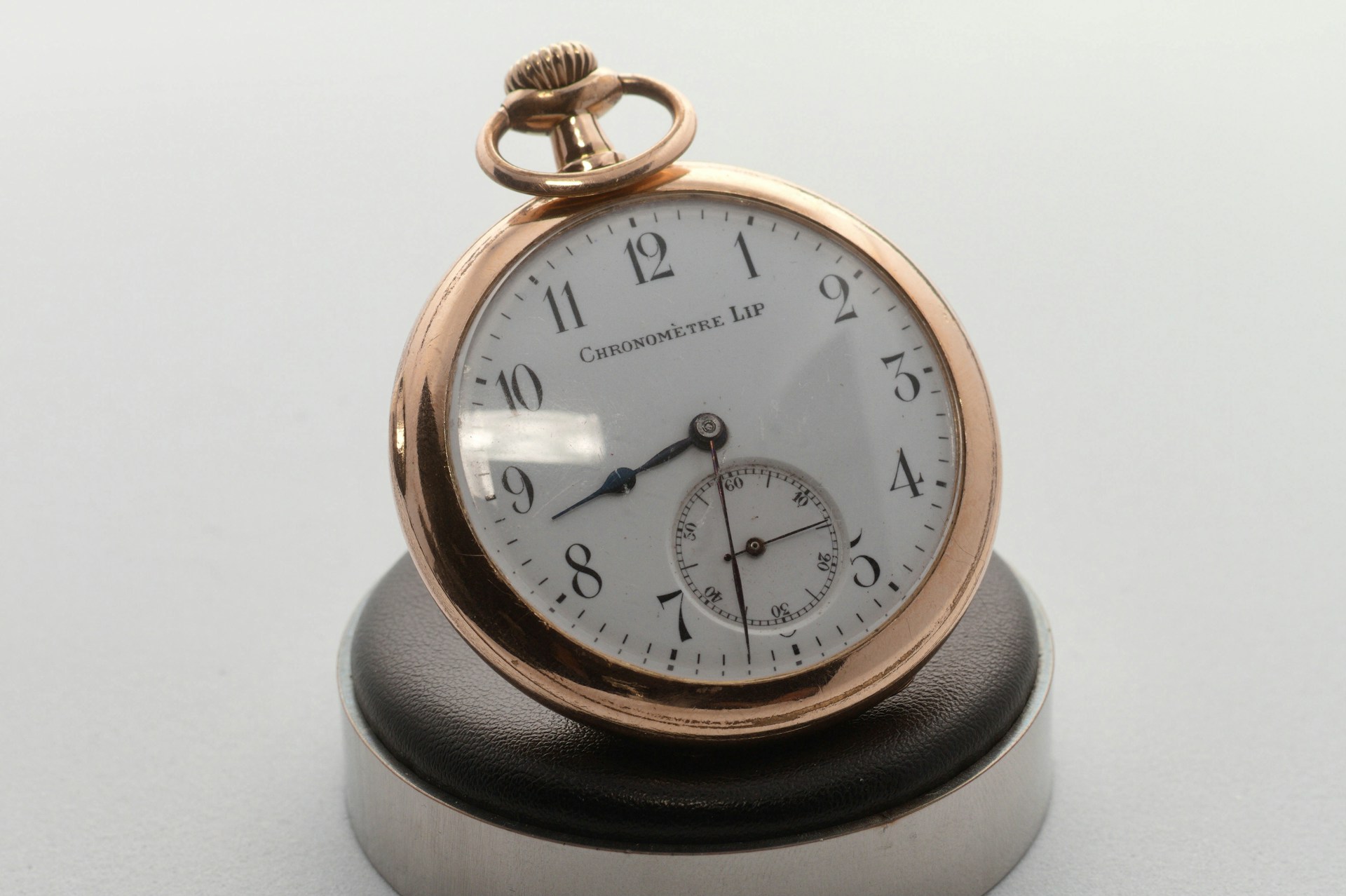 A close up of a pocket watch on a white surface