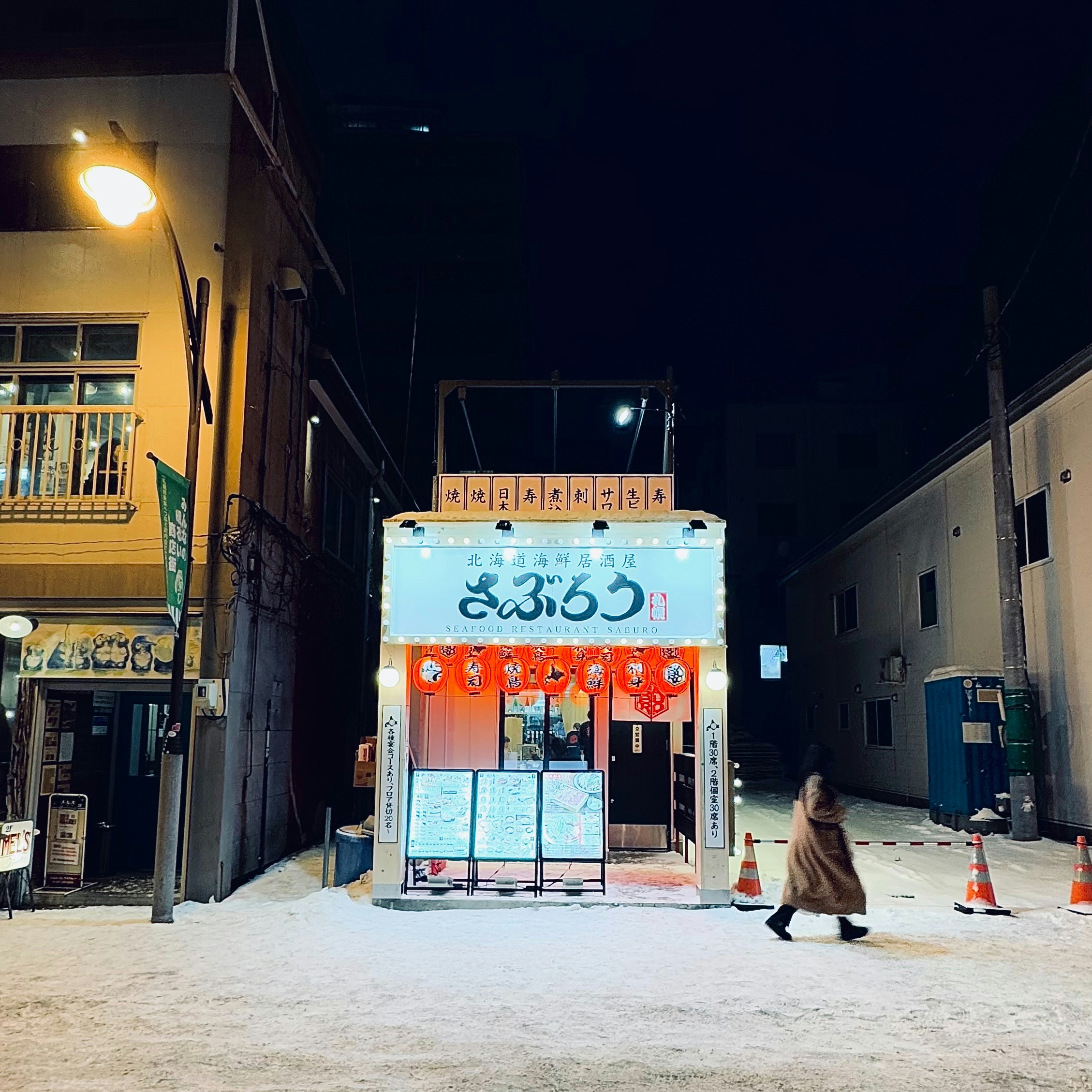 Eine Frau, die eine Straße neben hohen Gebäuden entlanggeht