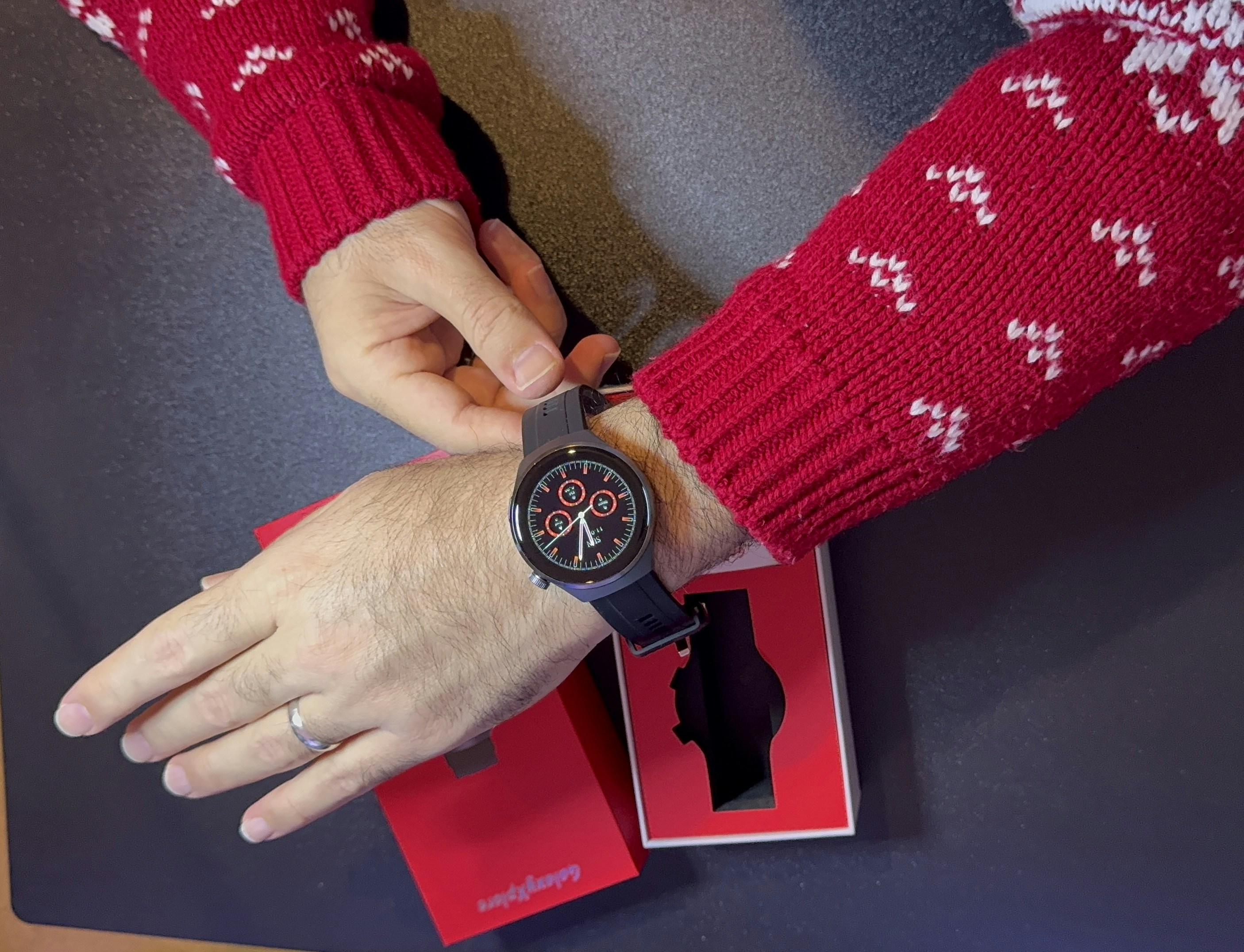 A person in a red sweater holding onto a watch