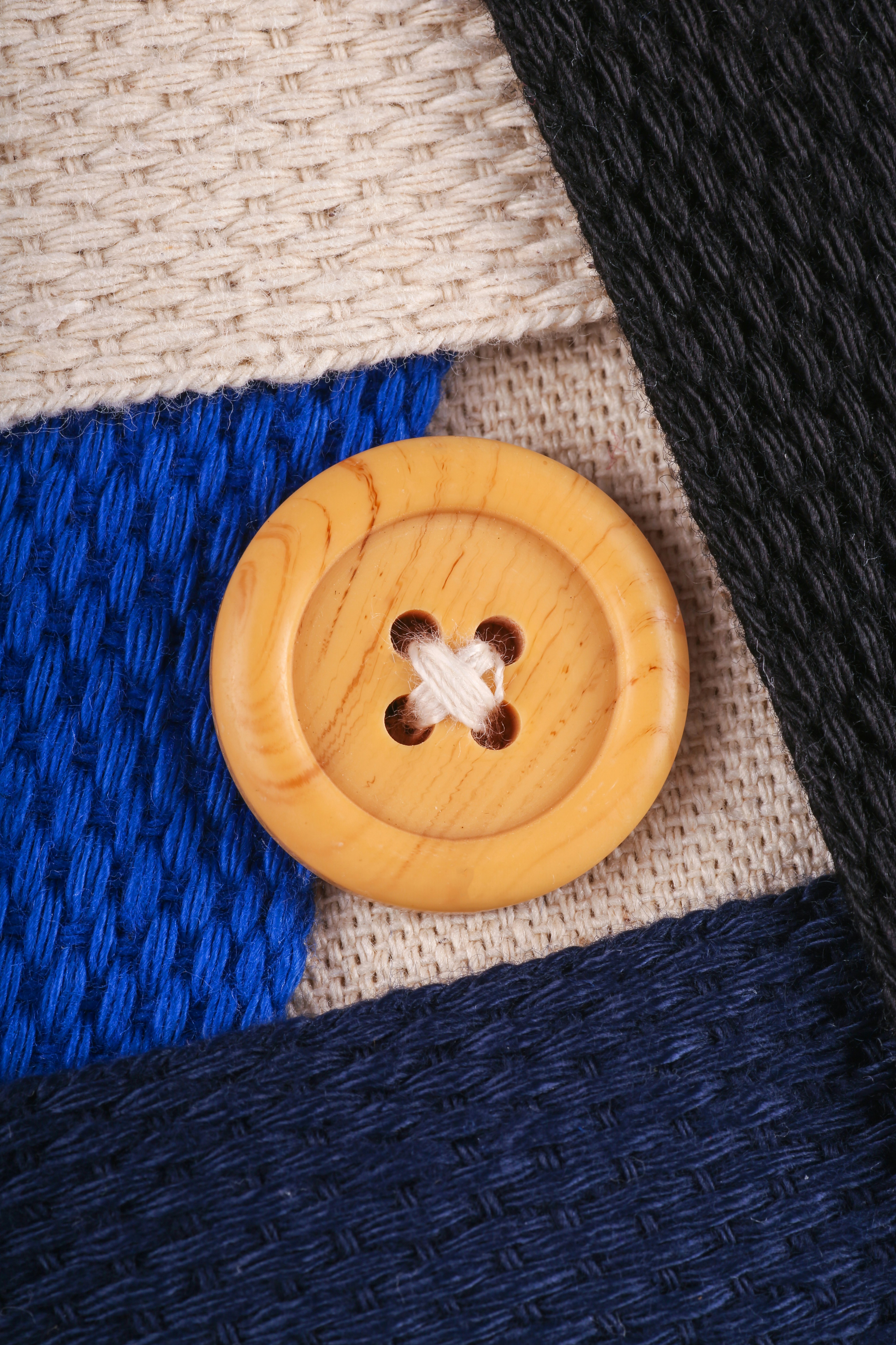 A wooden button on a blue and white sweater