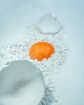 An orange is in the middle of a white bowl