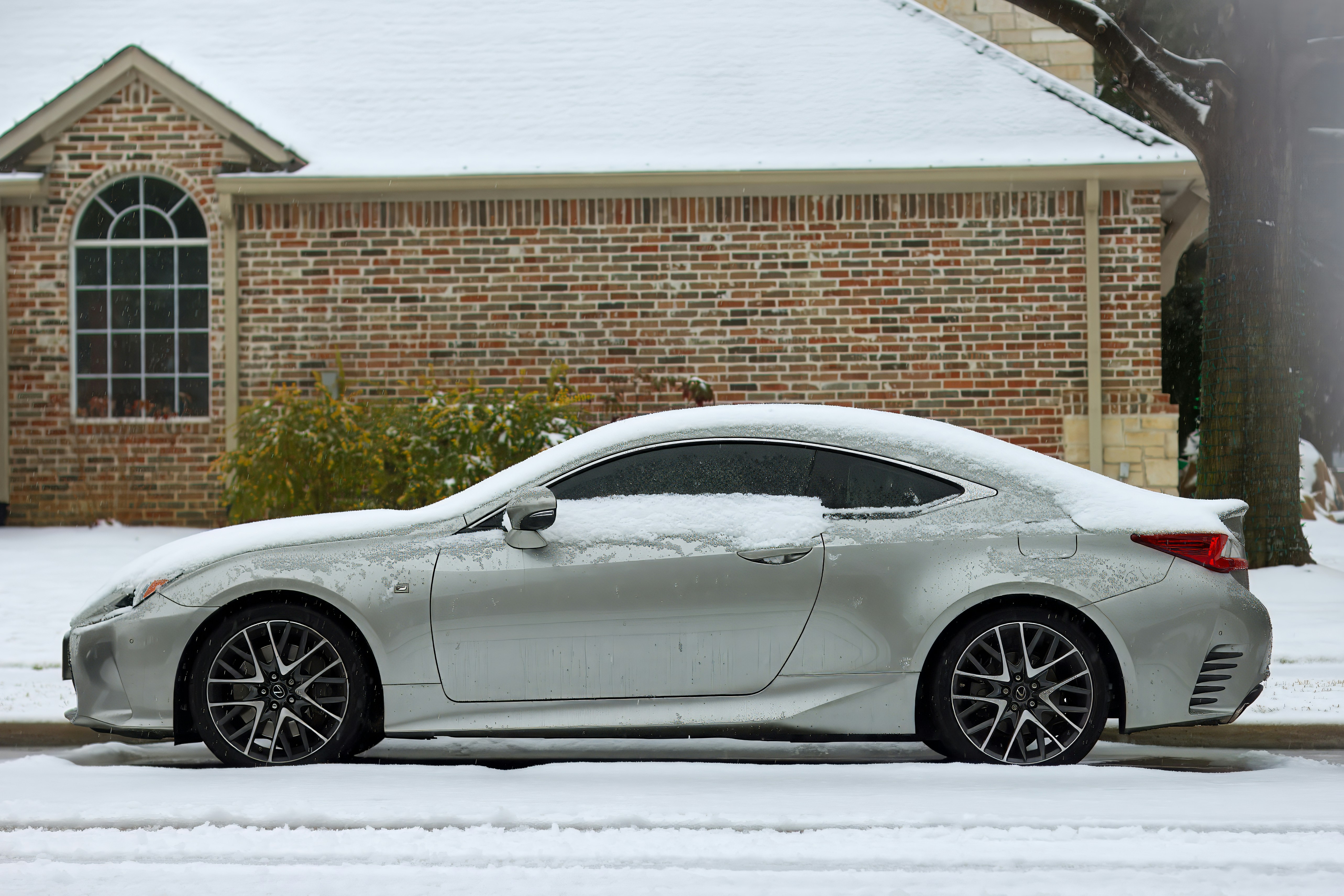 A white sports car parked in front of a house