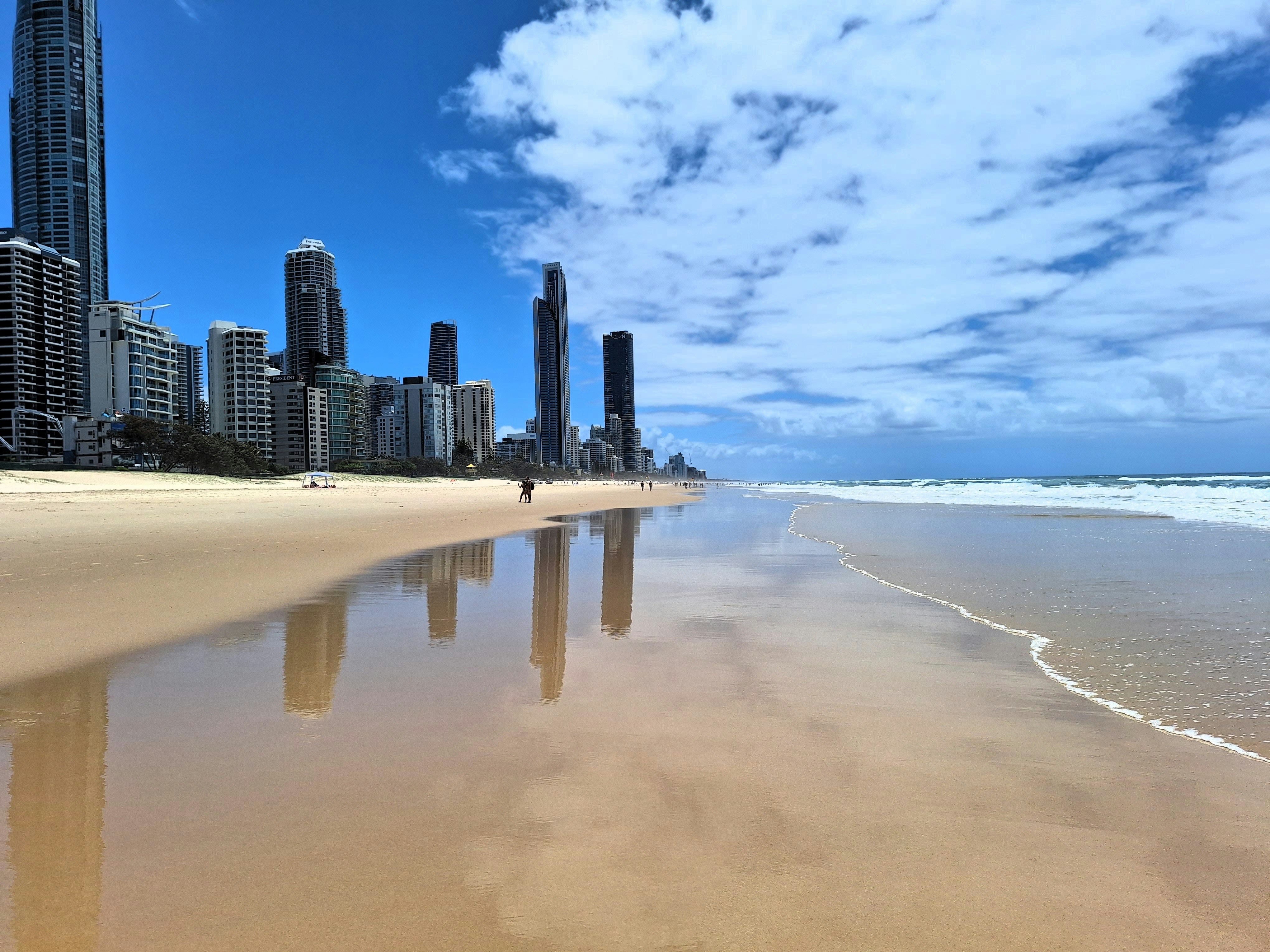 Una imagen de una playa con una ciudad al fondo