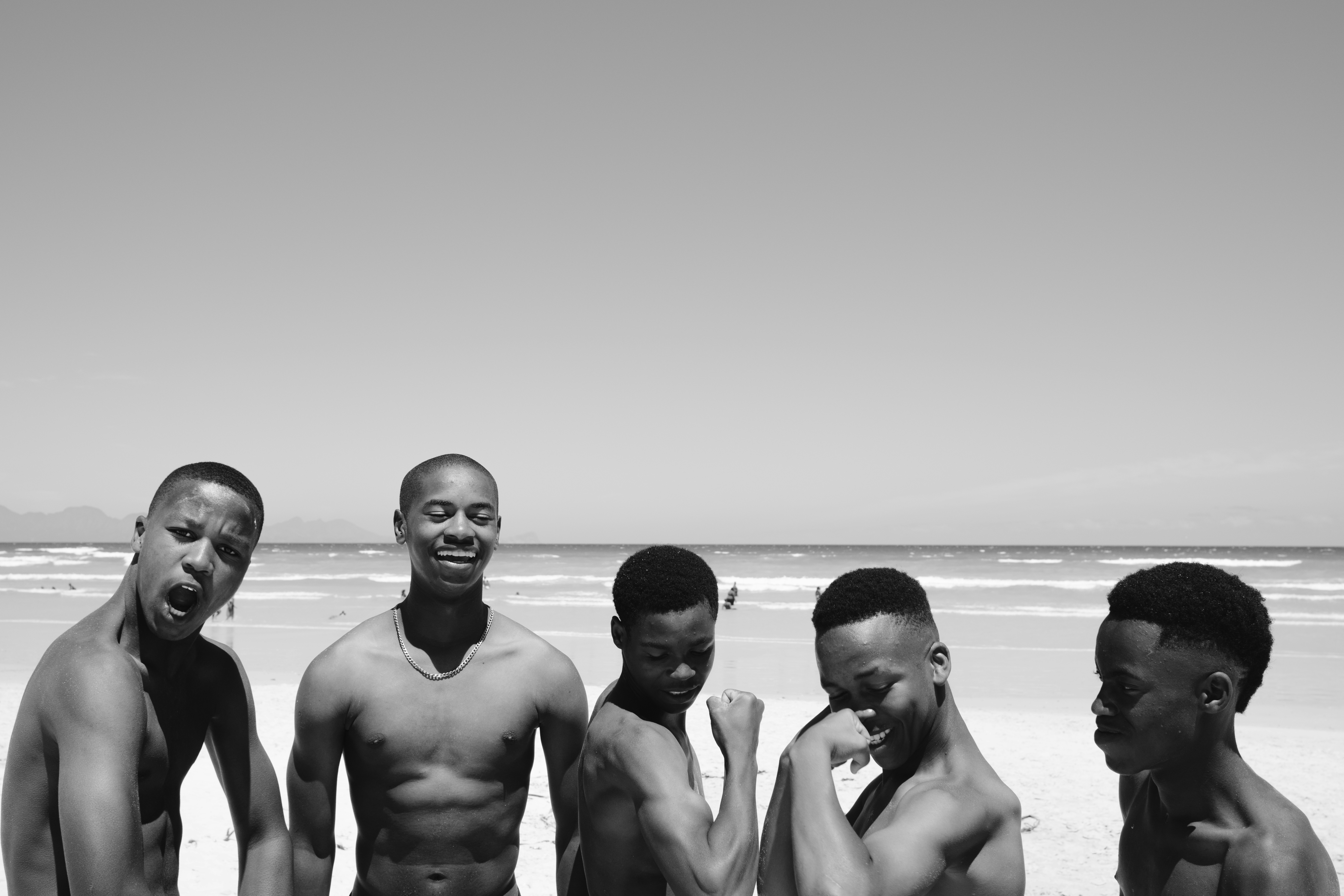 A group of men standing next to each other on a beach