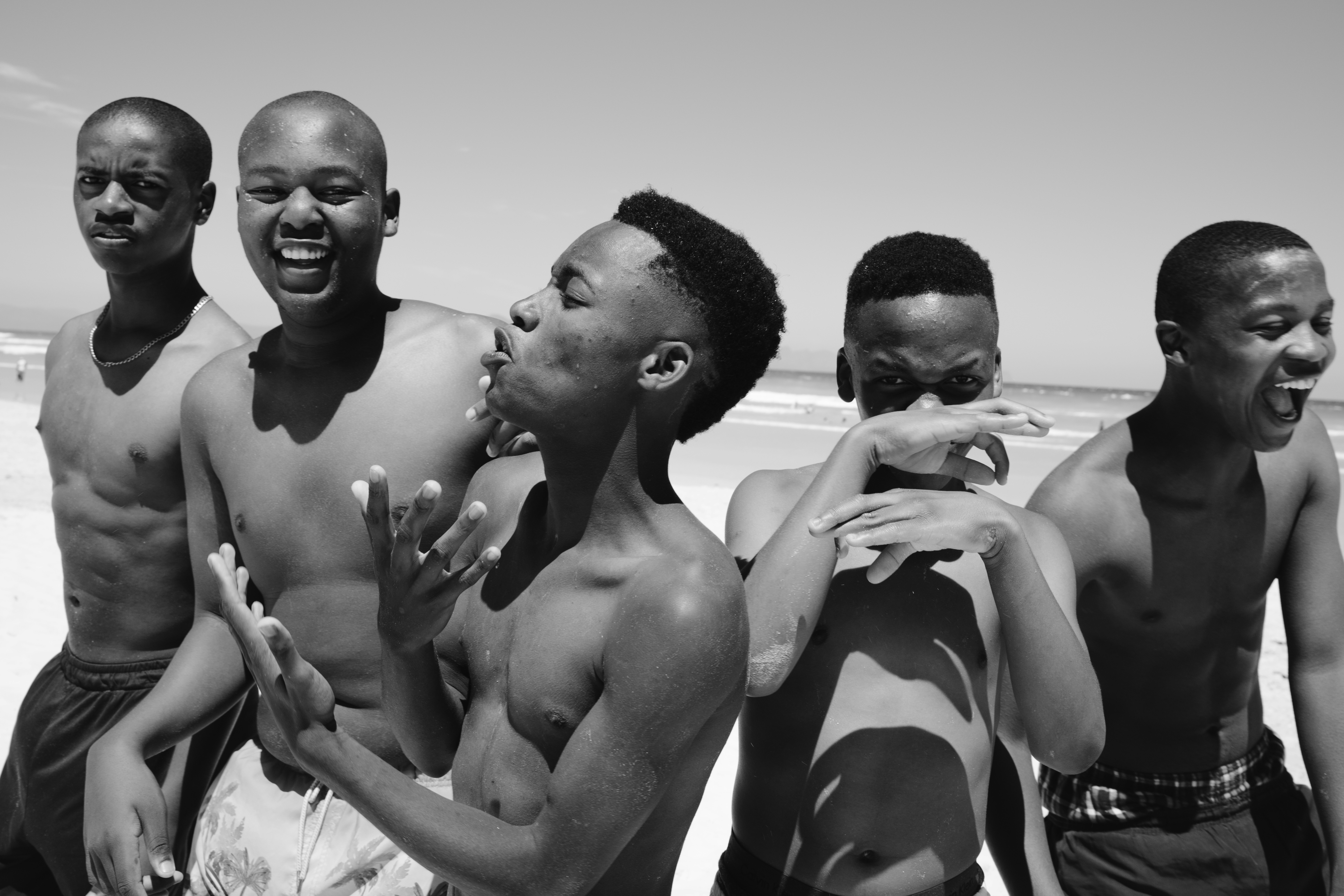 A group of men standing next to each other on a beach