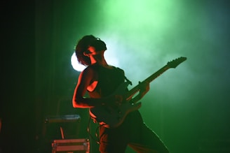 A person playing a guitar on a stage