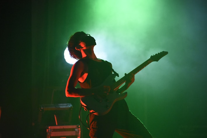 A person playing a guitar on a stage