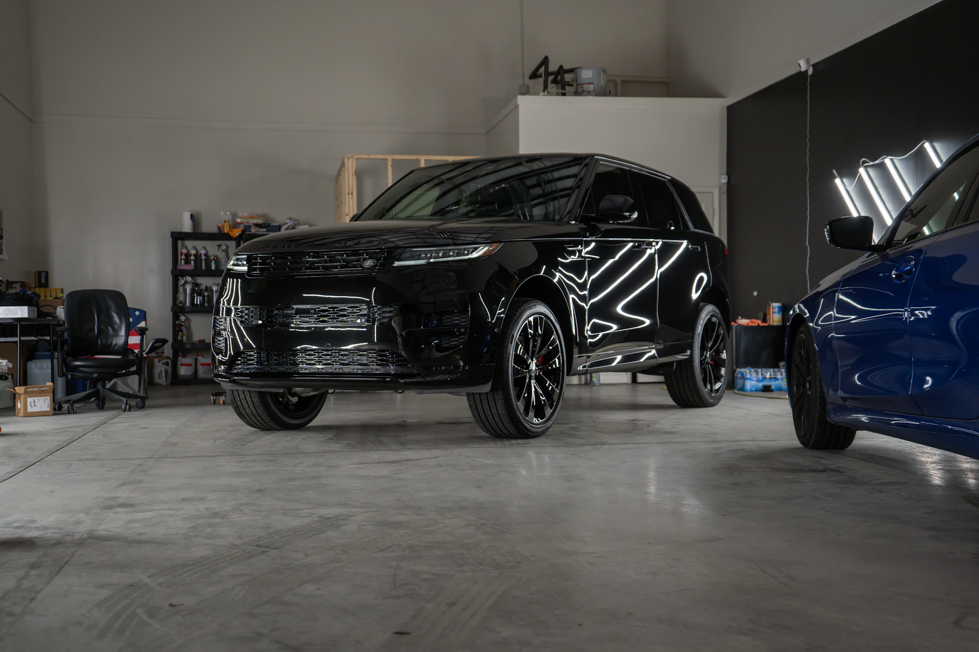Two cars parked in a garage next to each other