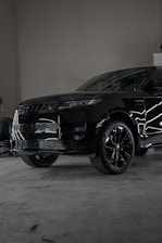 A black suv parked inside of a garage