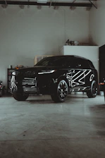 A black suv parked in a garage next to other vehicles