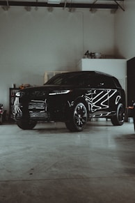 A black suv parked in a garage next to other vehicles