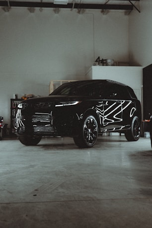 A black suv parked in a garage next to other vehicles