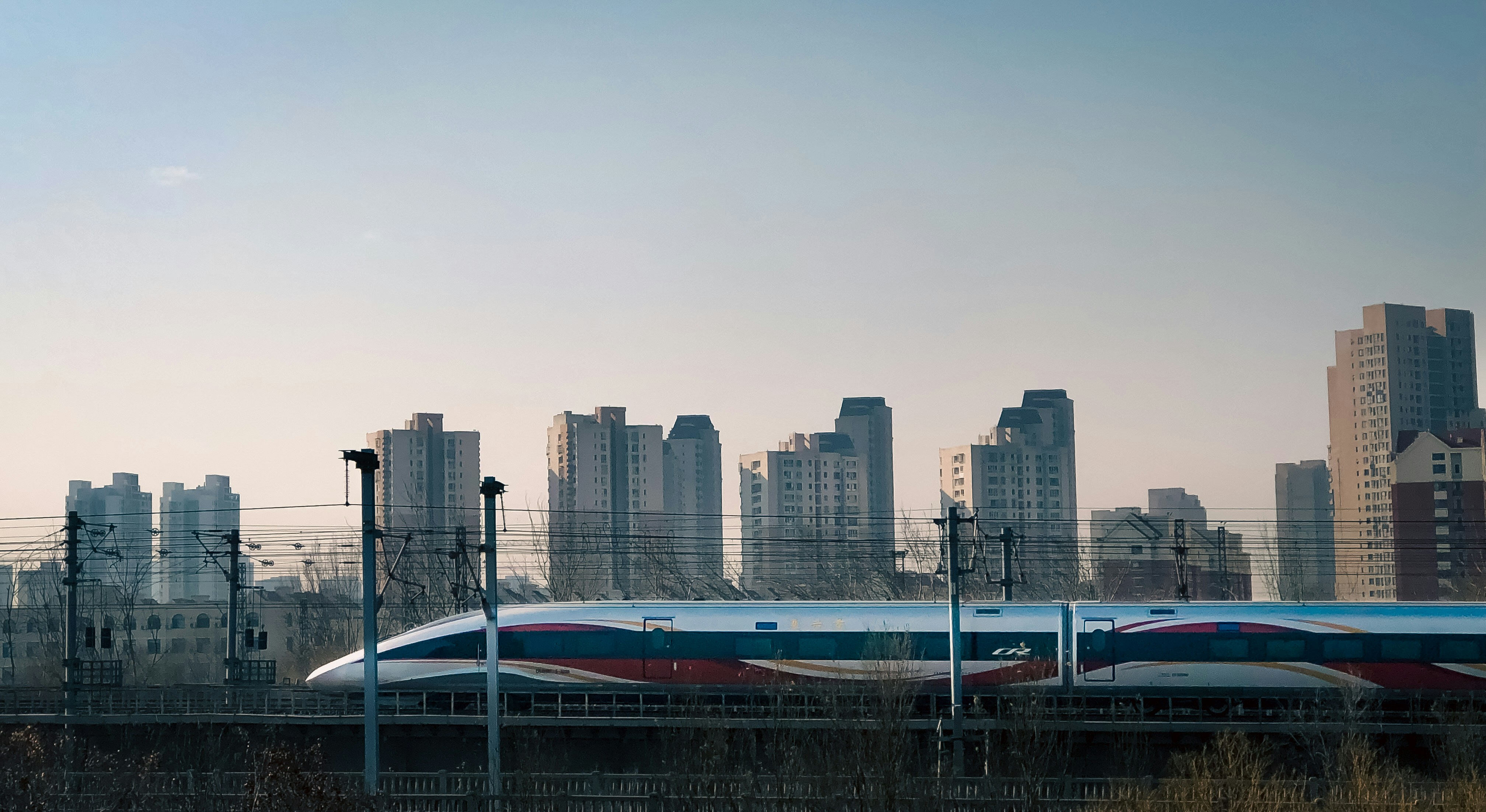 A train traveling through a city next to tall buildings photo – Free ...