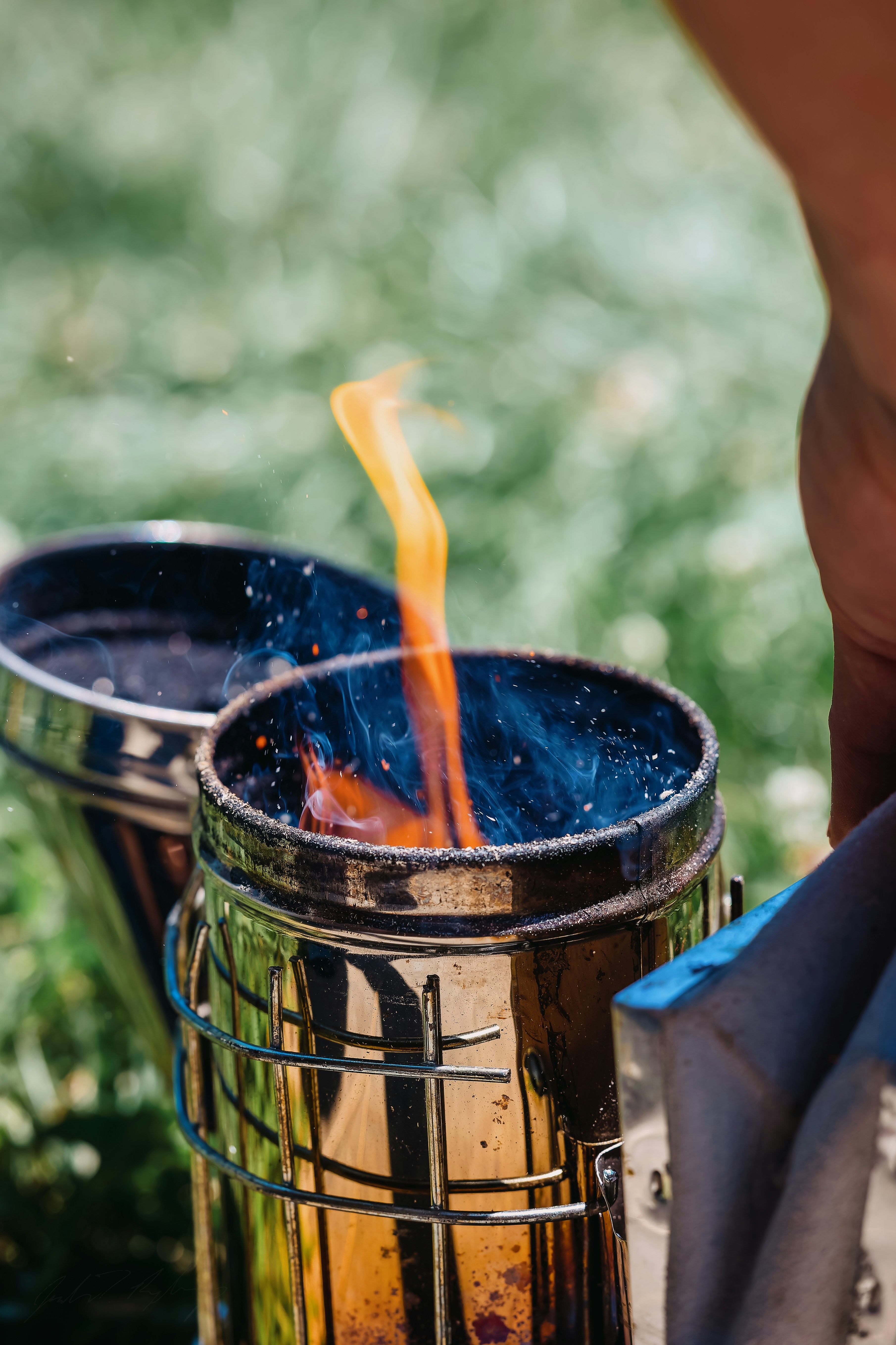 A person standing next to a metal trash can
