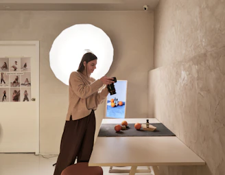 A woman standing in front of a table with a bottle of wine