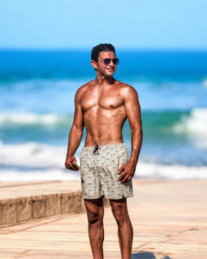 A man standing on a beach next to the ocean