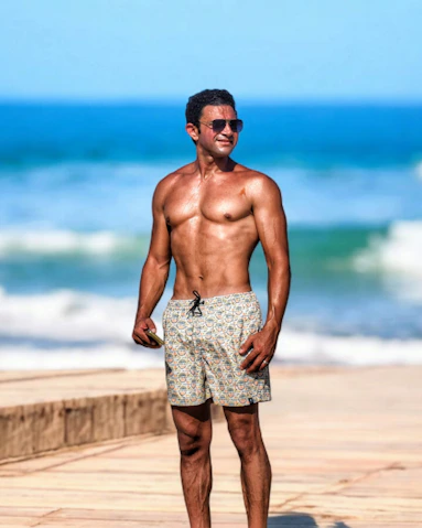 A man standing on a beach next to the ocean
