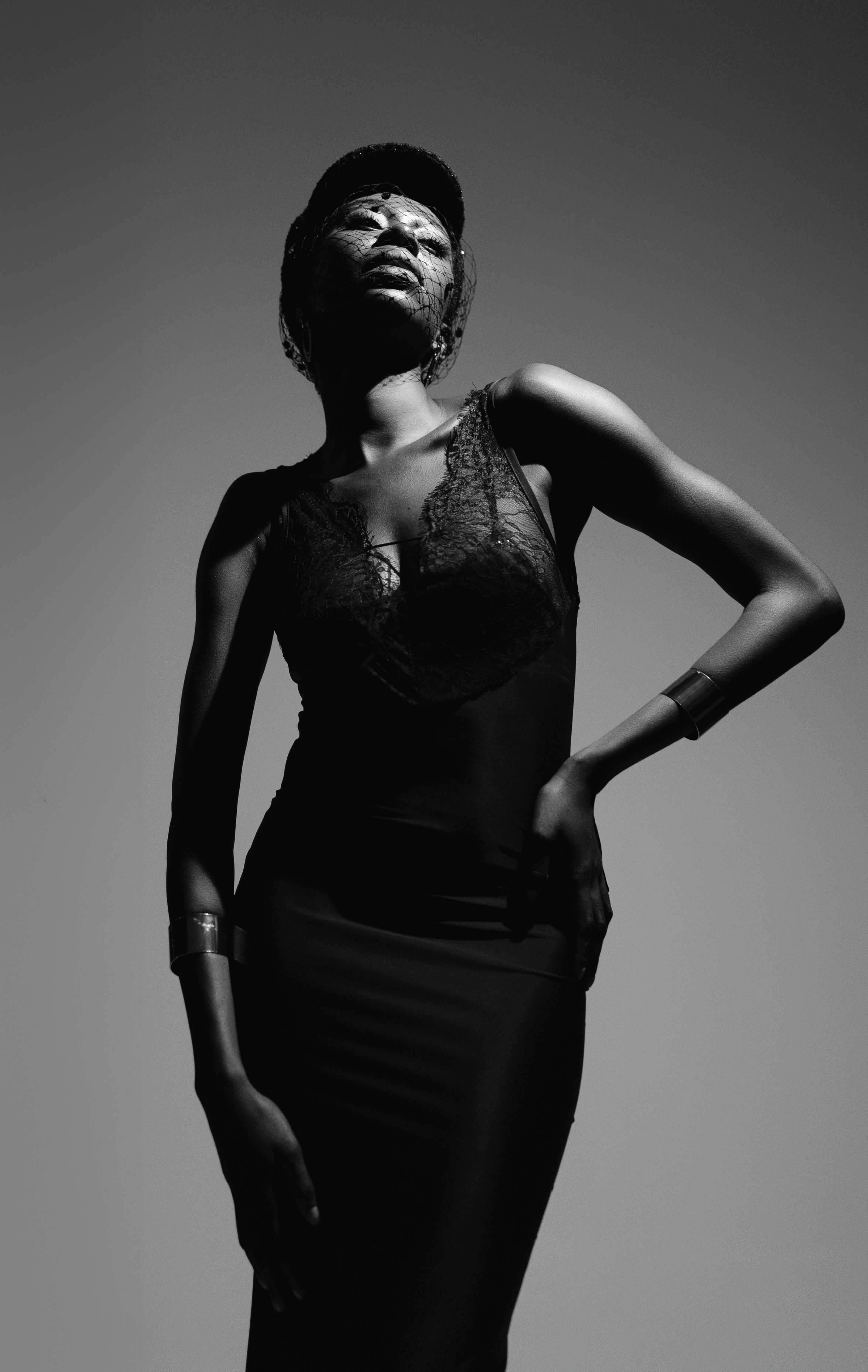 A woman in a black dress standing with her hands on her hips