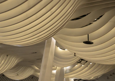 The ceiling of a large building with white columns