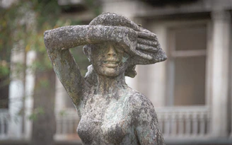 A statue of a woman with a hat on her head