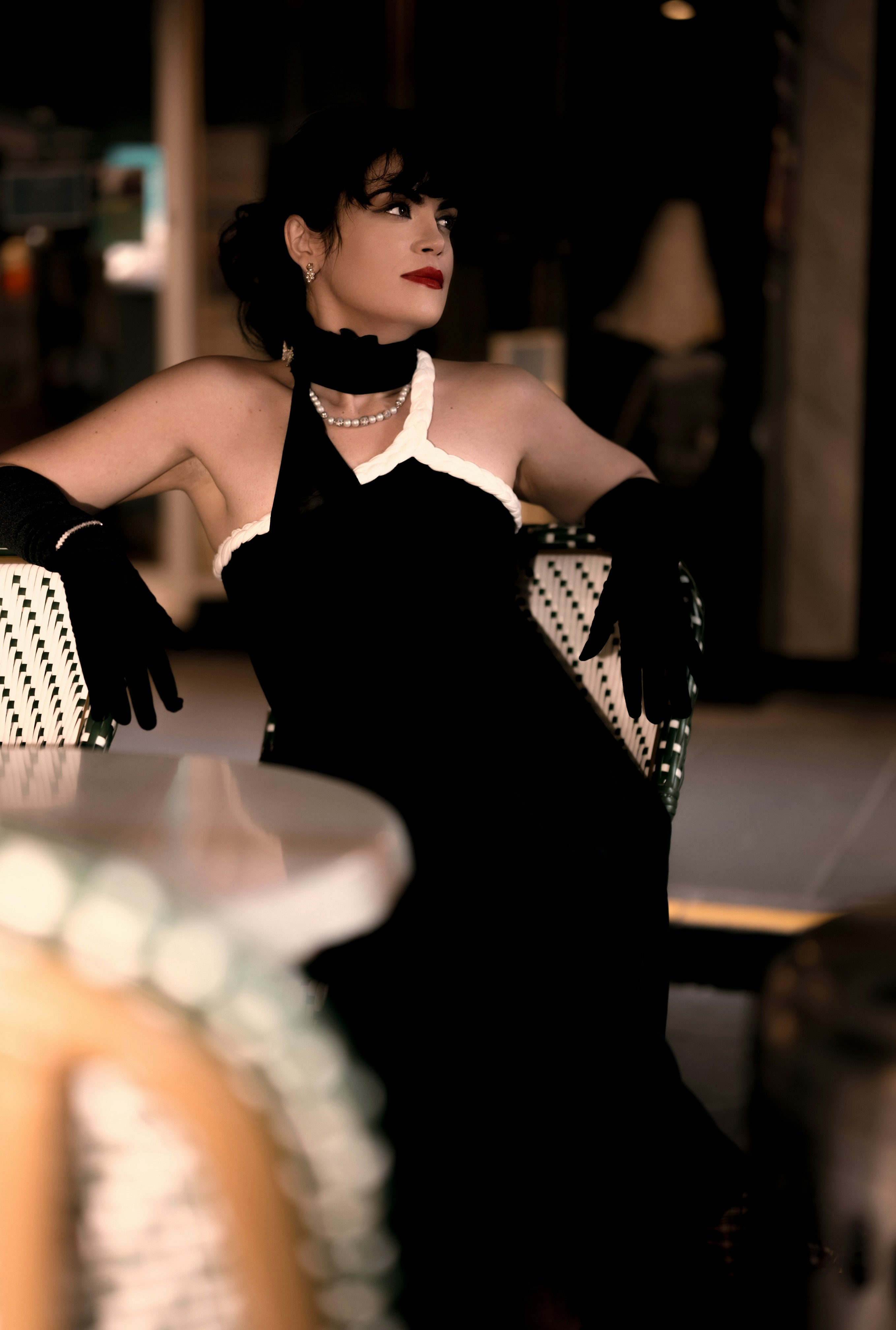 A woman in a black dress sitting on a chair