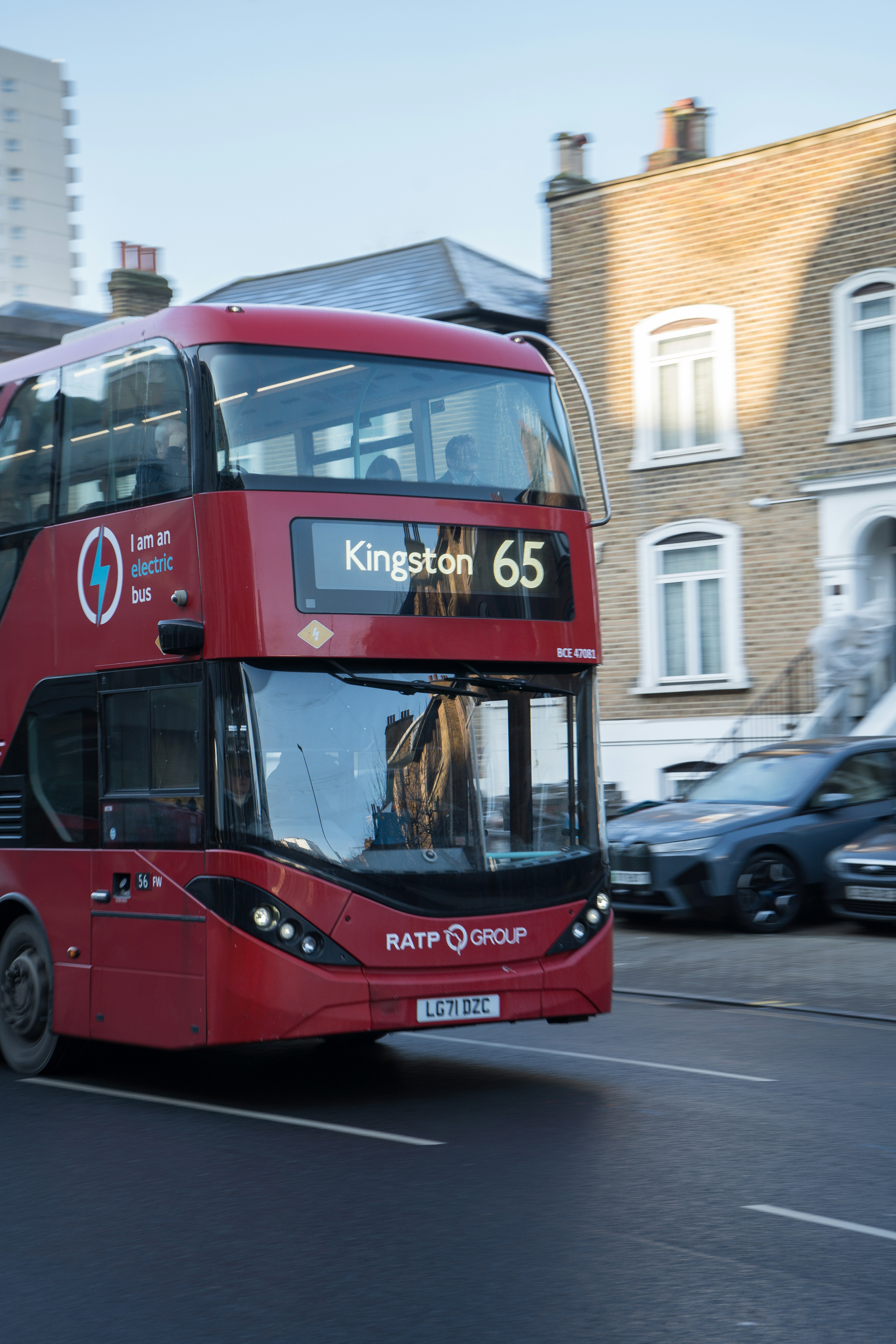 A red double decker bus driving down a street photo – Free London Image ...