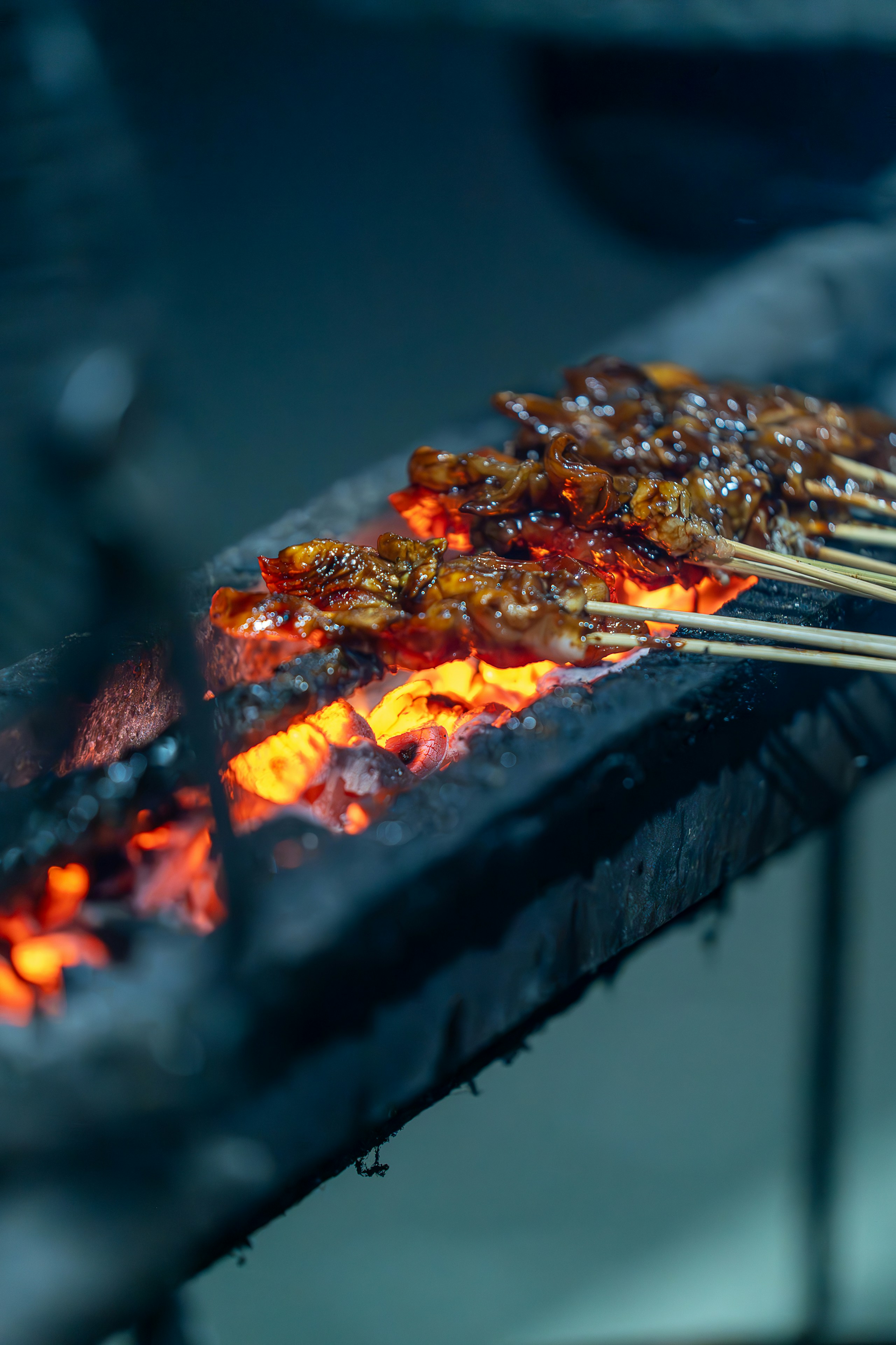 A close up of a grill with skewers of food on it