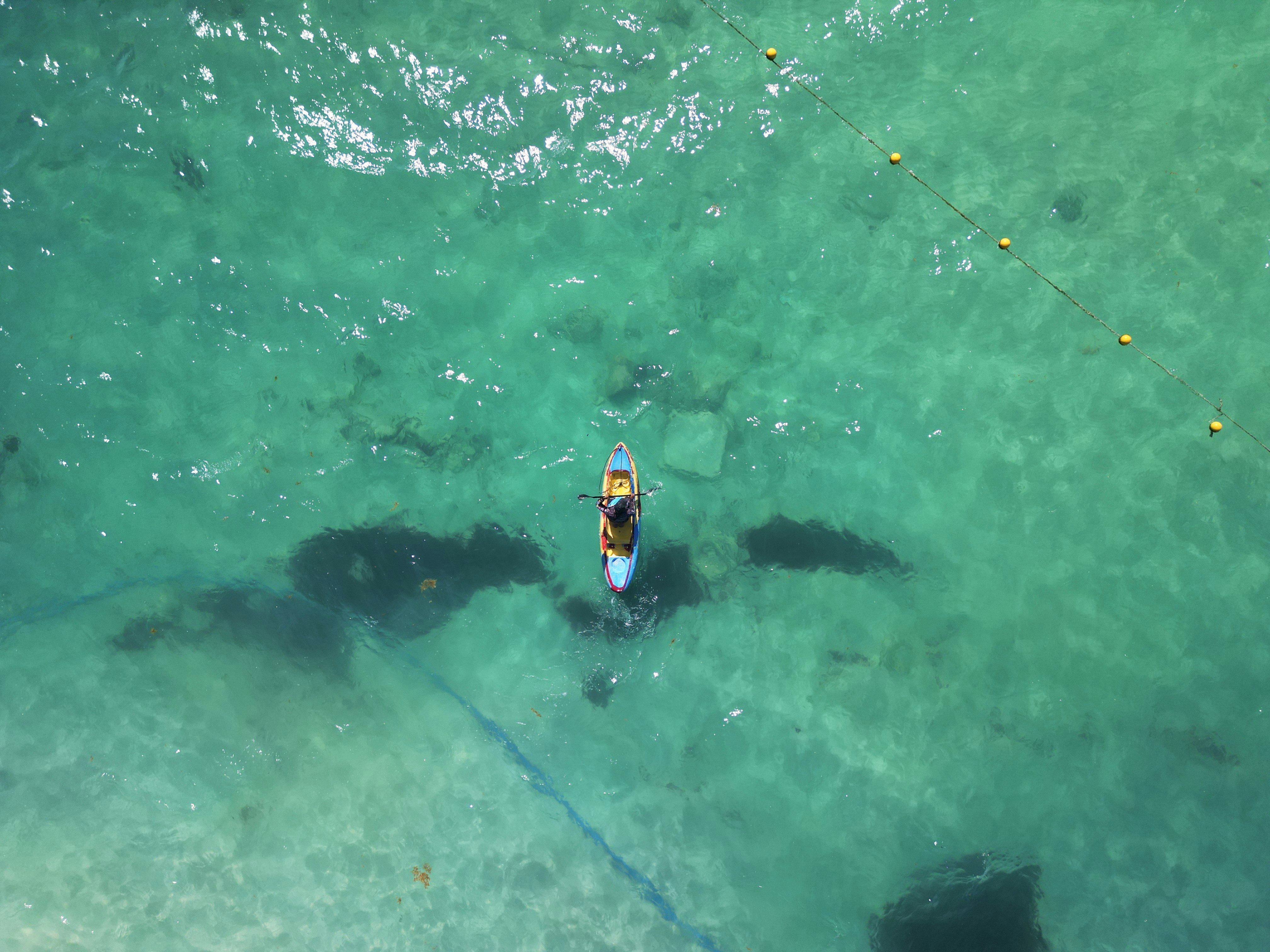 An aerial view of a man in a kayak in the ocean