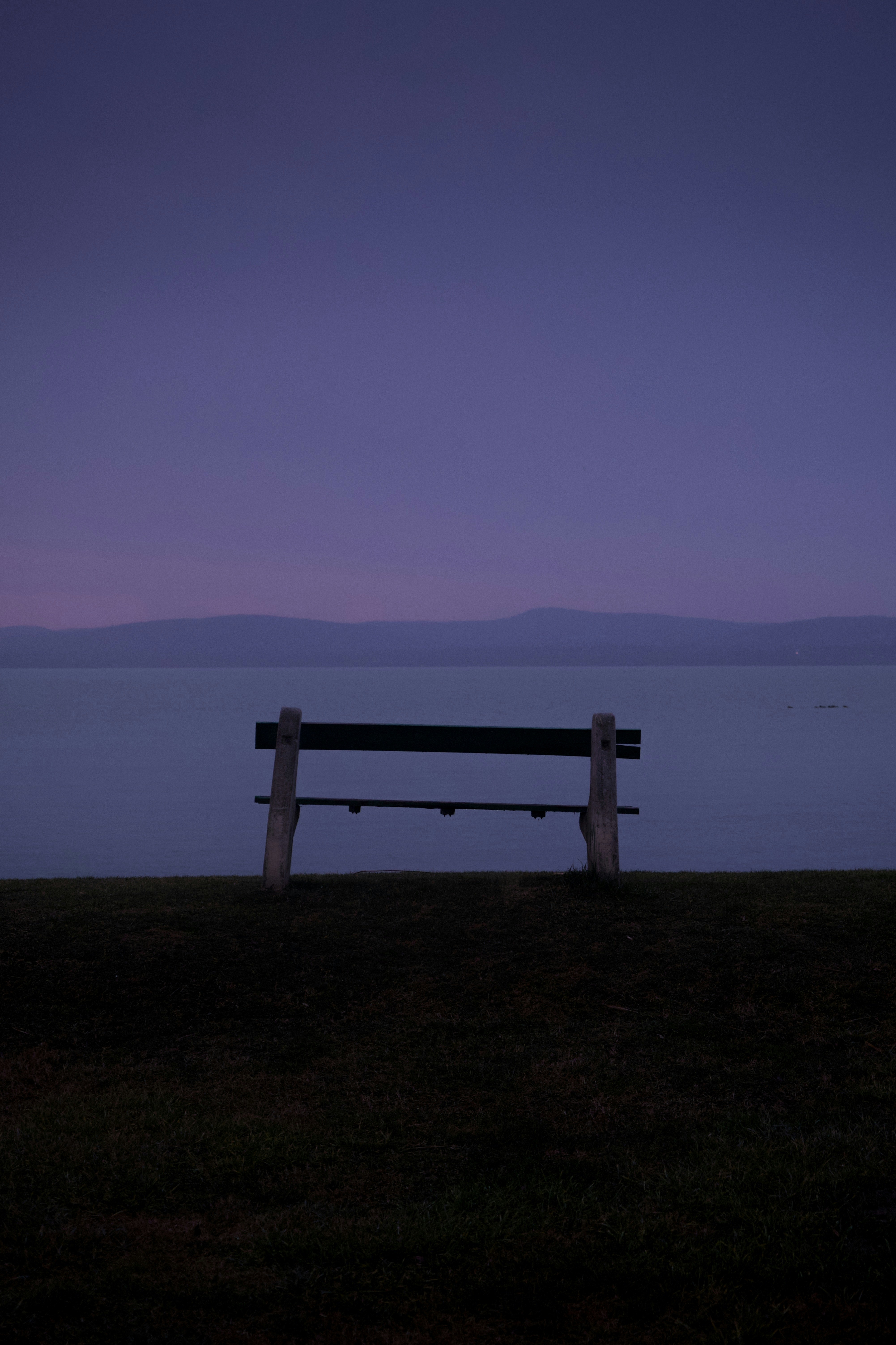 Una panchina seduta in cima a un campo coperto di erba