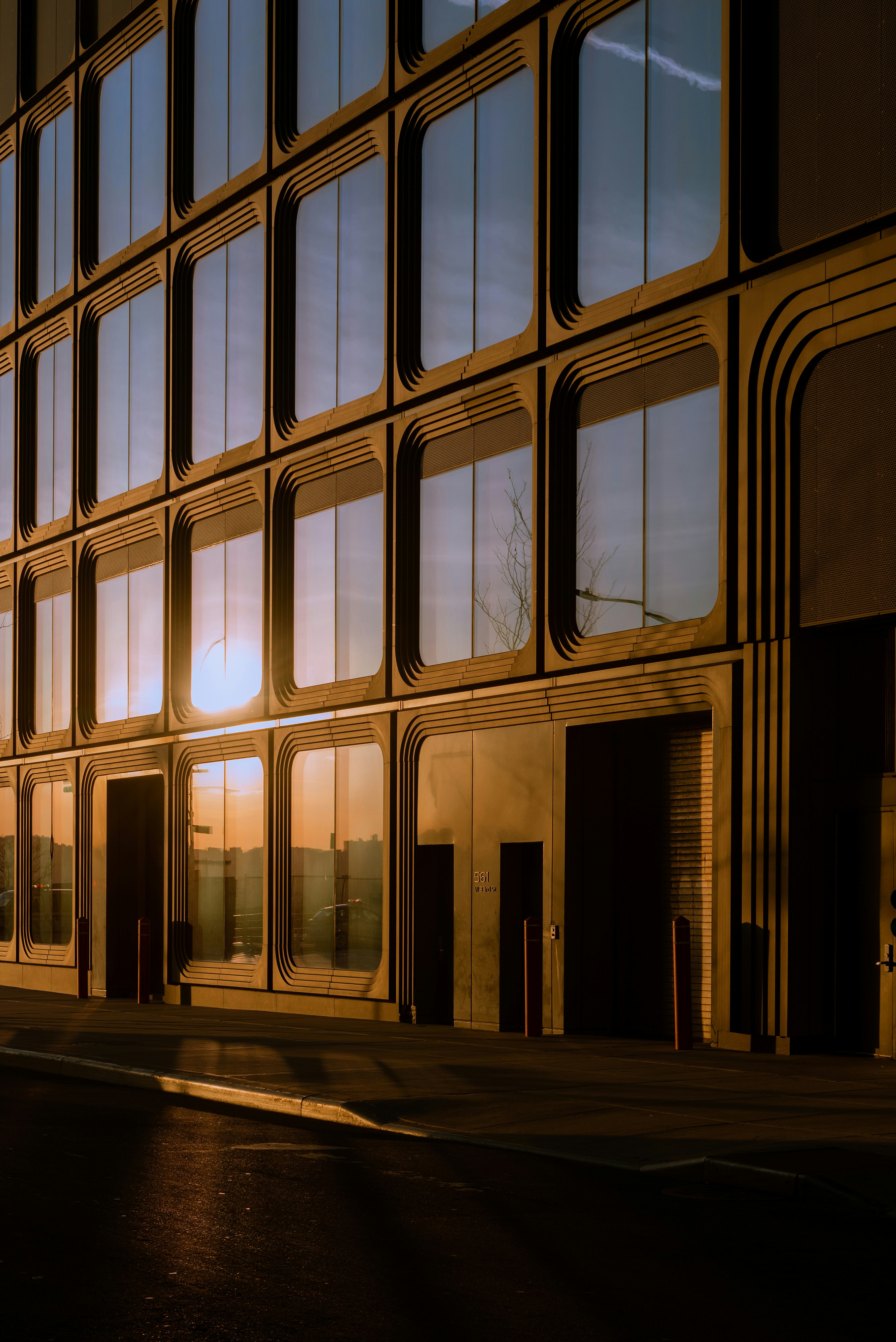 A tall building with lots of windows next to a street