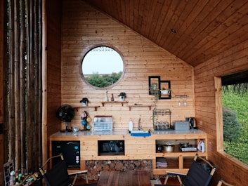 A living room with a round window and wooden walls