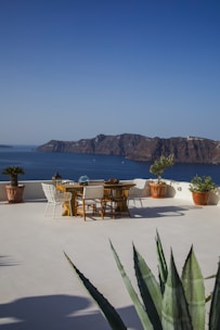 A patio with a table and chairs overlooking the ocean