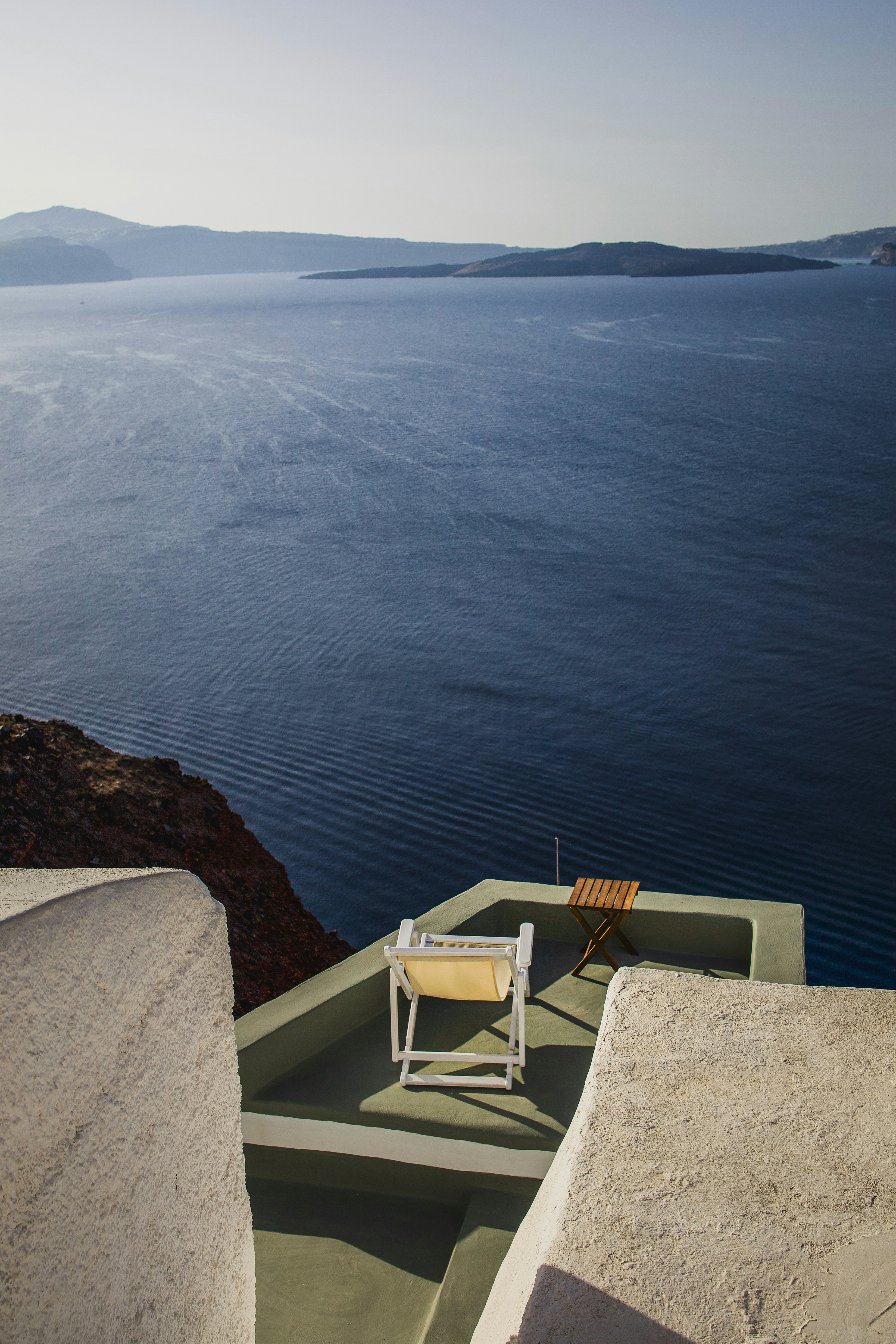 A chair sitting on top of a roof next to a body of water