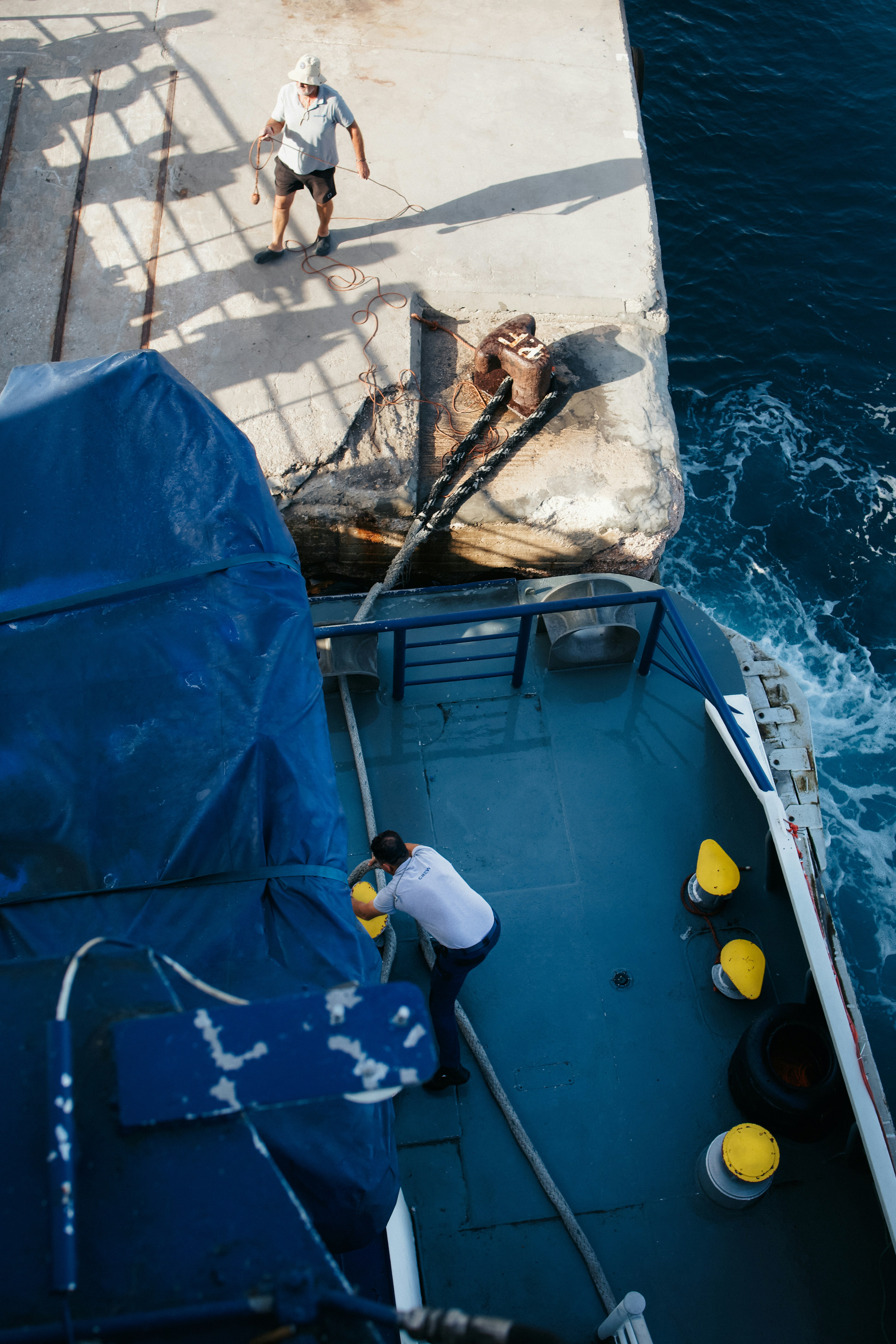 A man standing on the back of a boat in the water