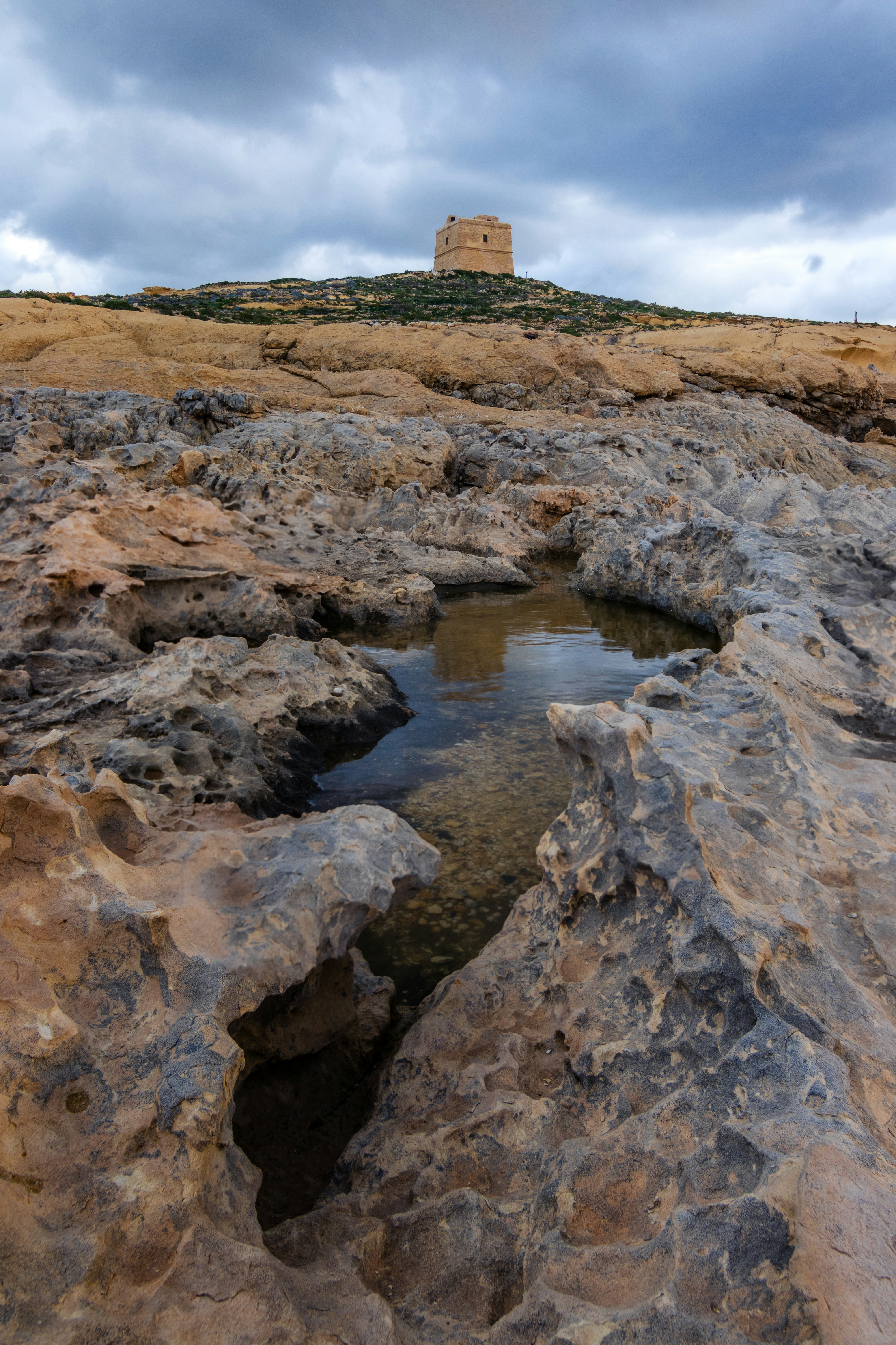 A small pool of water in the middle of some rocks