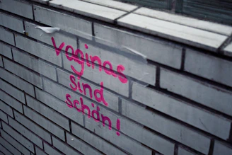 A brick wall with graffiti written on it