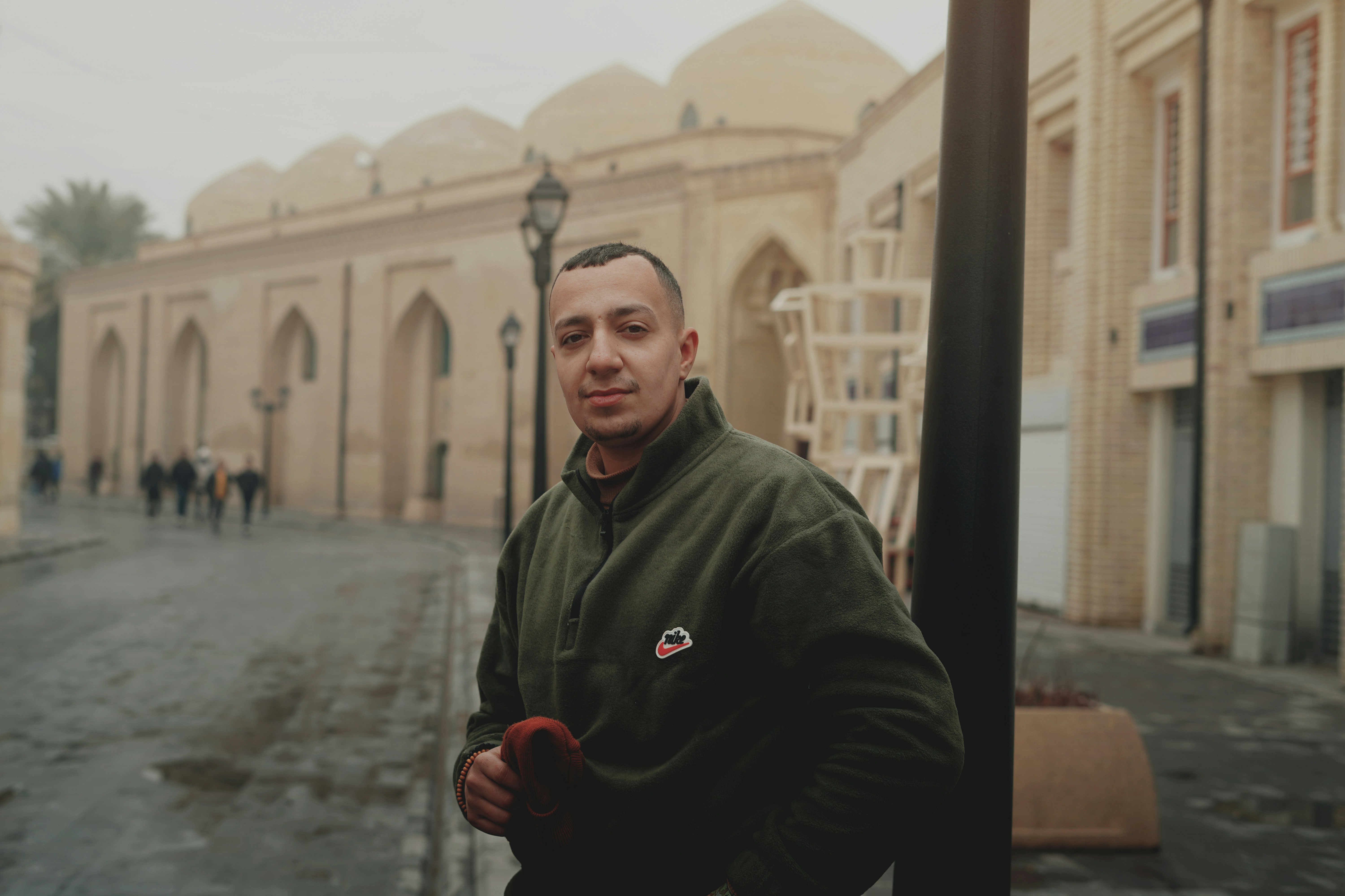 A man standing on a street corner in front of a building