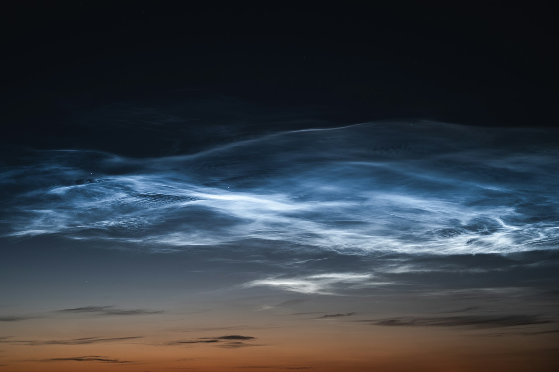 A plane flying in the sky at sunset