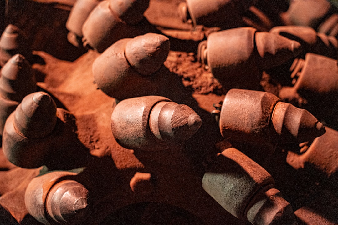 A pile of clay that is sitting on a table, A powerful coal mining machine with massive metal teeth, standing as a symbol of industrial strength and hard work, showcasing the legacy of coal mining in its raw and mechanical form.