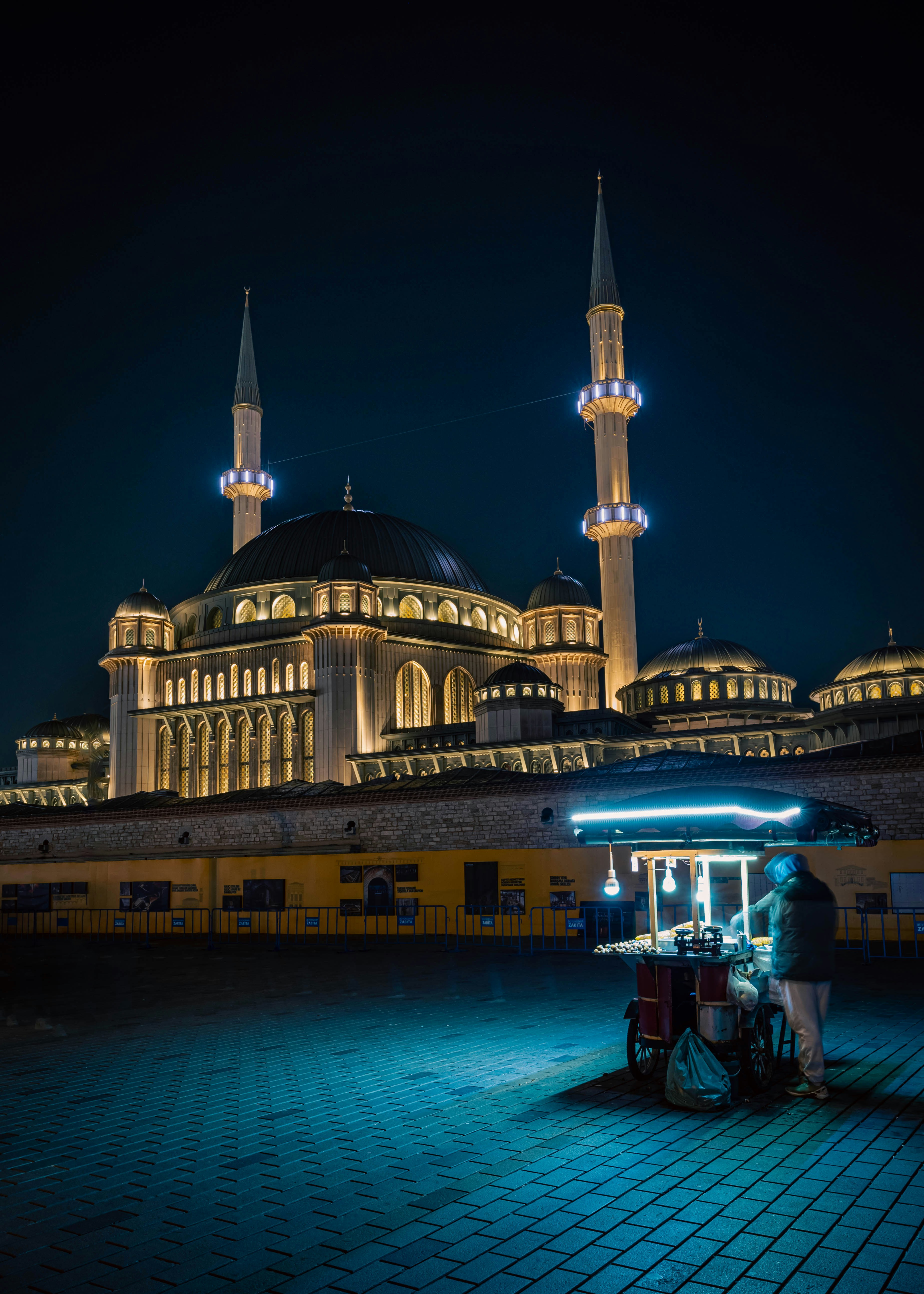 A person standing in front of a building at night