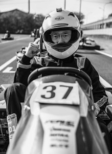 A man sitting in a race car with a helmet on