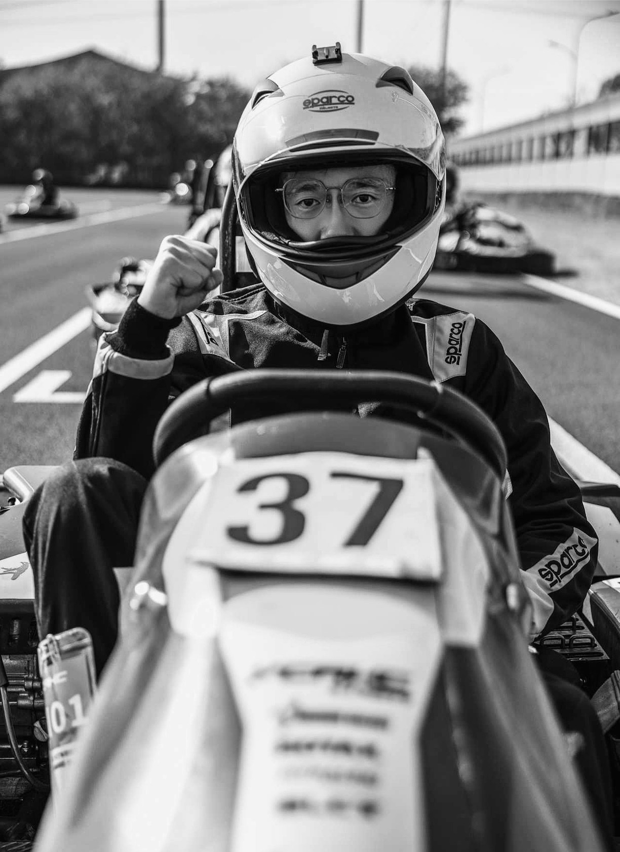 A man sitting in a race car with a helmet on