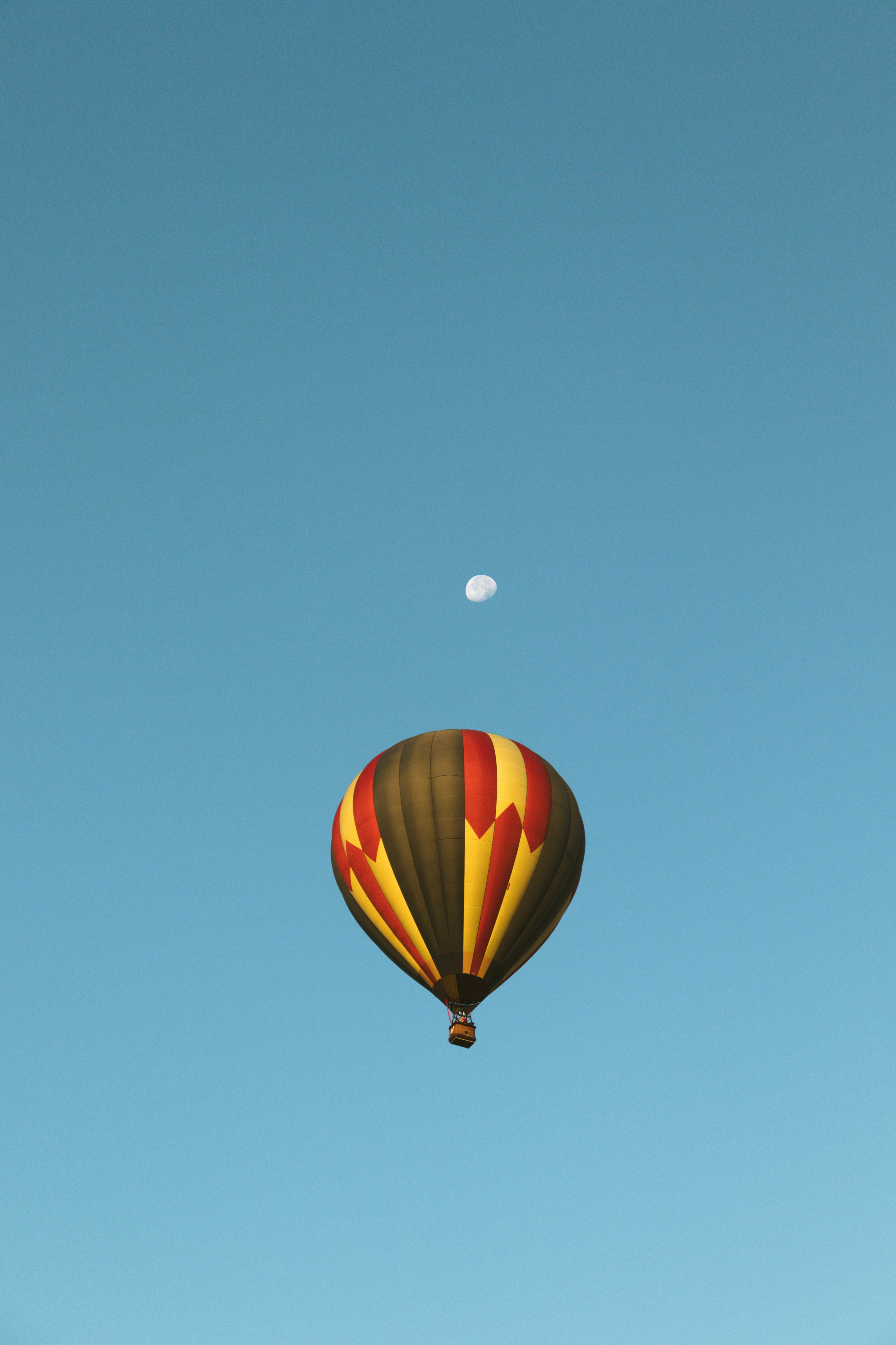 A hot air balloon flying through a blue sky photo – Free Vehicle Image ...