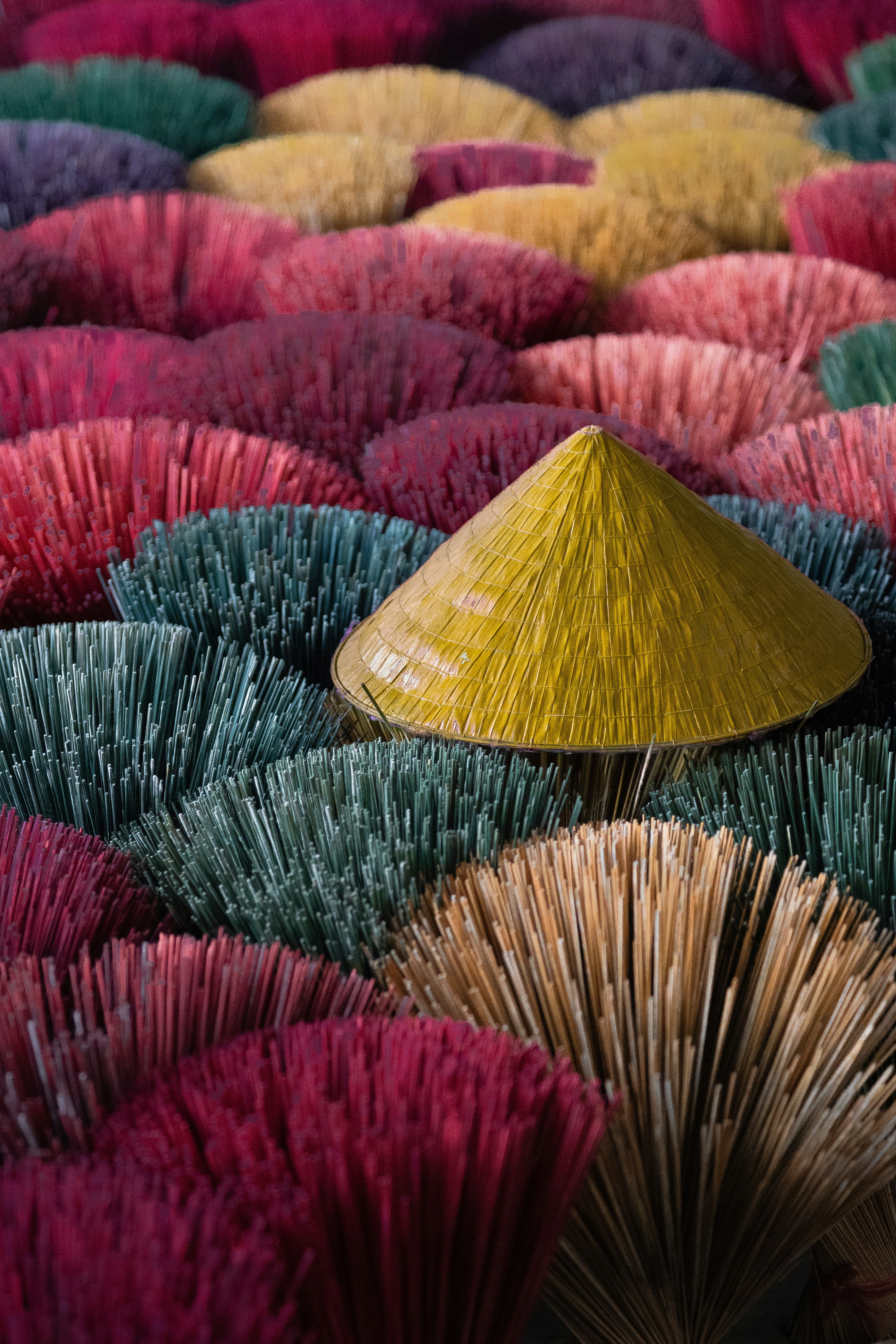 A large amount of different colored plants with a yellow cone on top