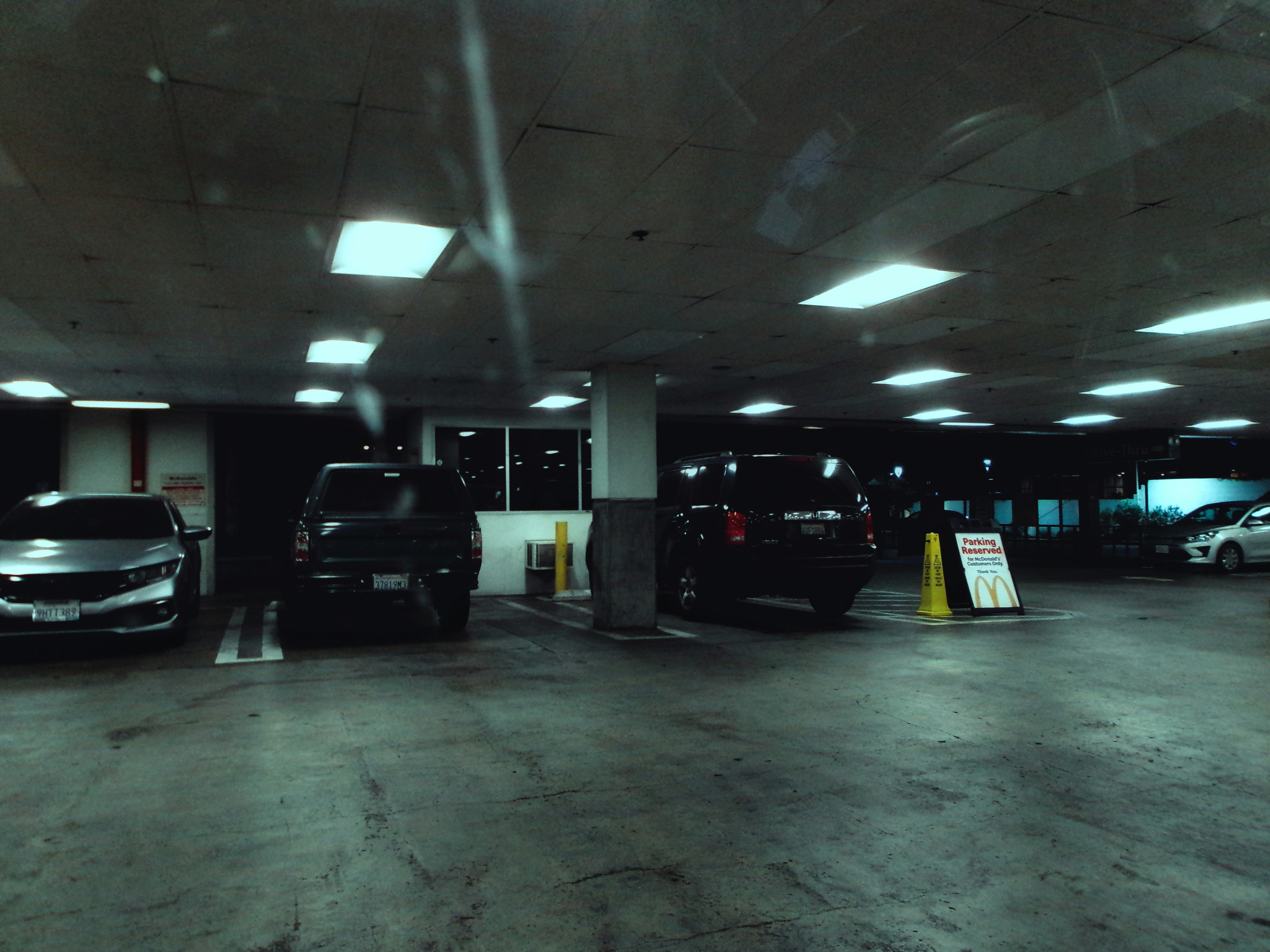 well-lit apartment parking garage with multiple EV charging stations - apartments with EV parking