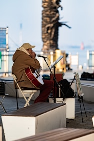 A man sitting in a chair playing a guitar